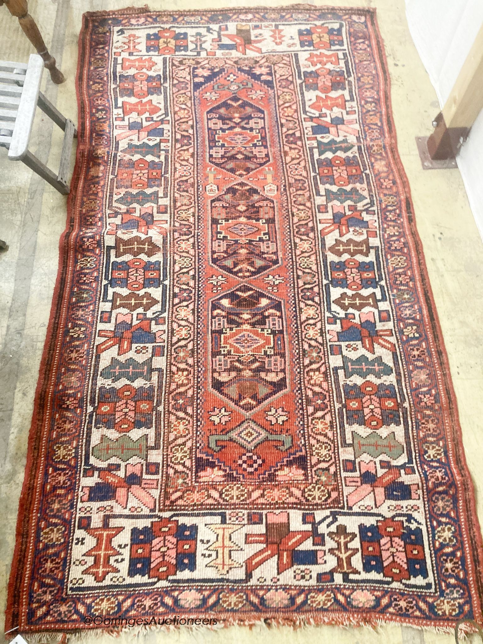 A Caucasian red ground rug, 218 x 112cm                                                                                                                                                                                     