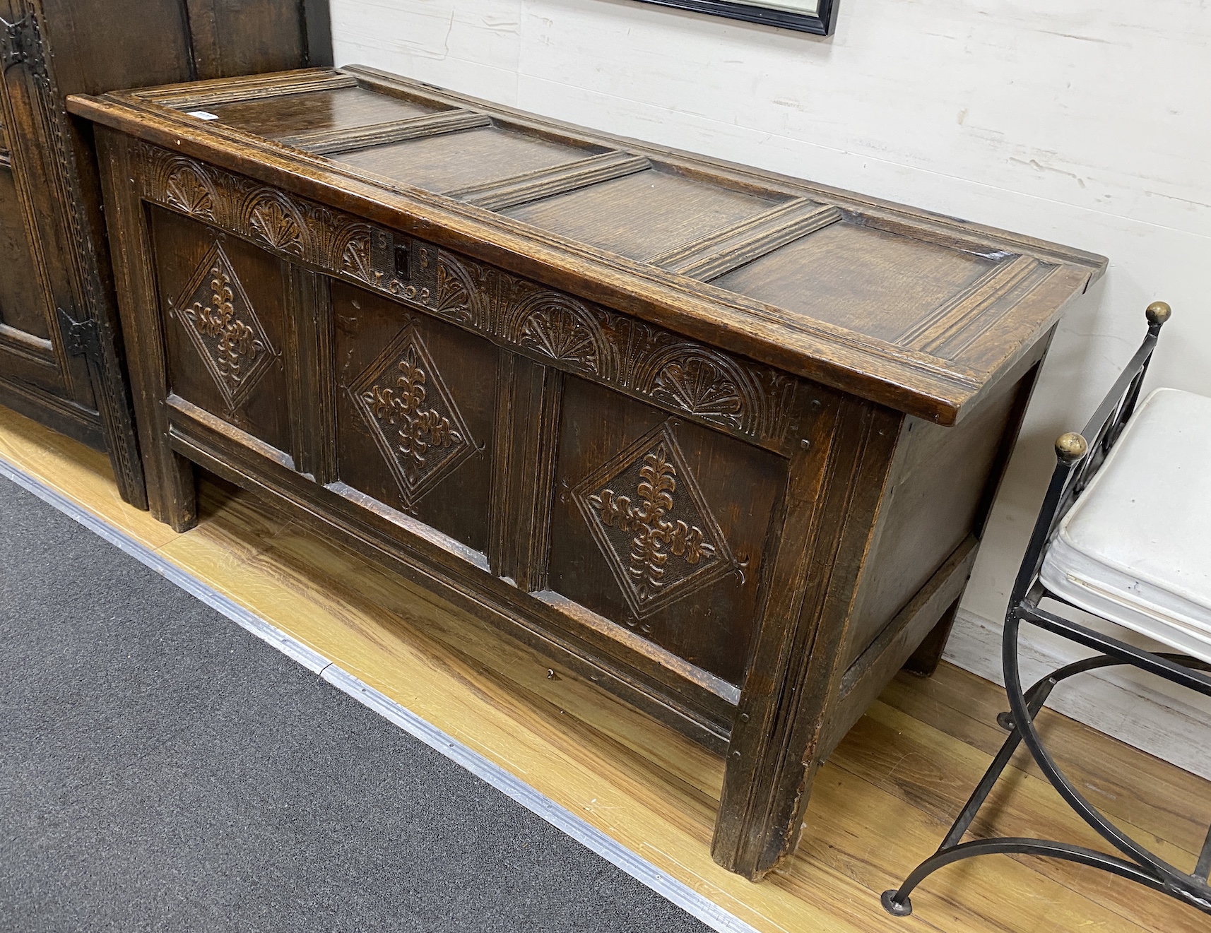 A late 17th century oak coffer, with a panelled top and lozenge carved front, length 128cm, depth 56cm, height 70cm                                                                                                         