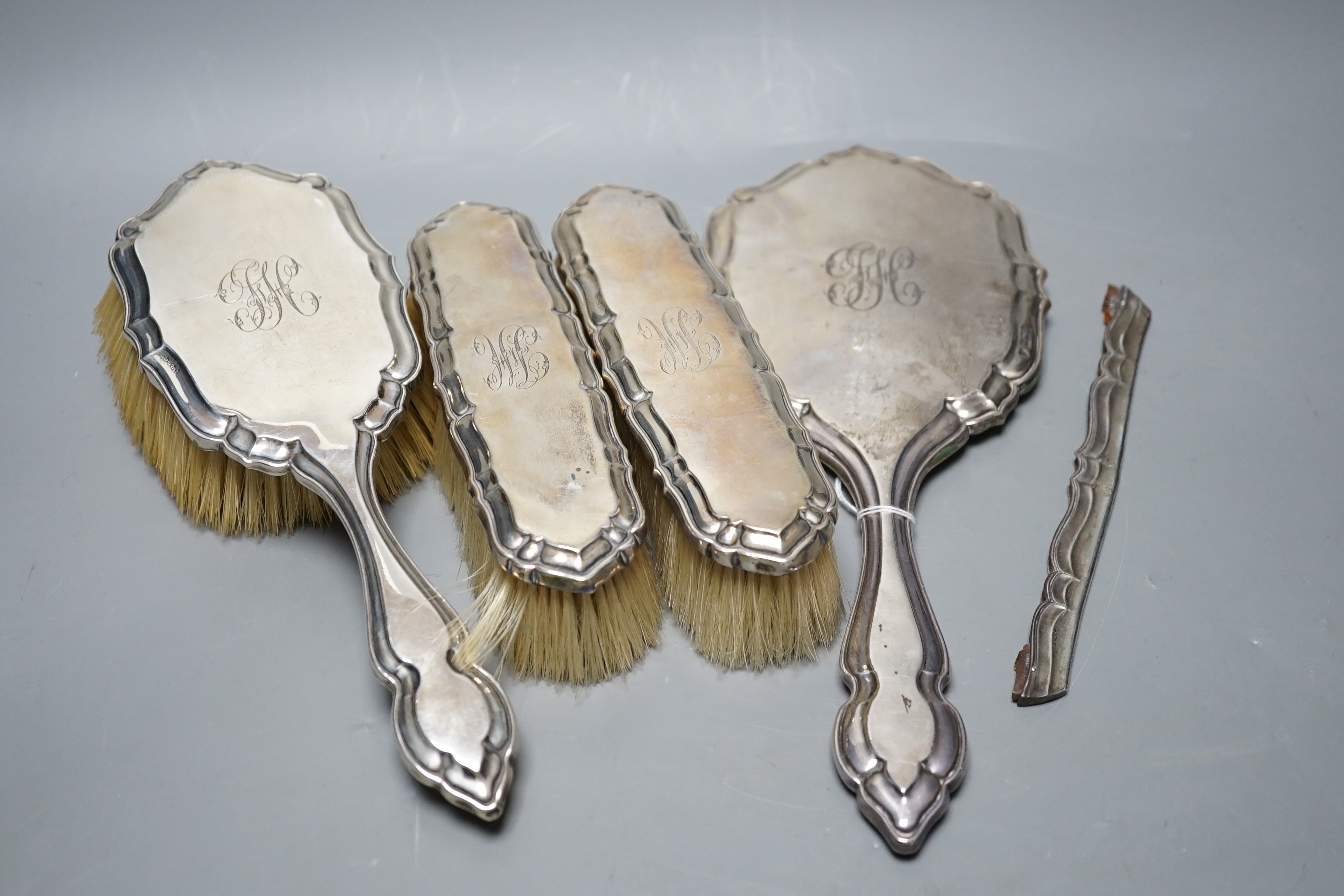A George V silver five piece dressing table set, by Charles & Richard Comyns, London, 1917, (comb teeth missing).                                                                                                           