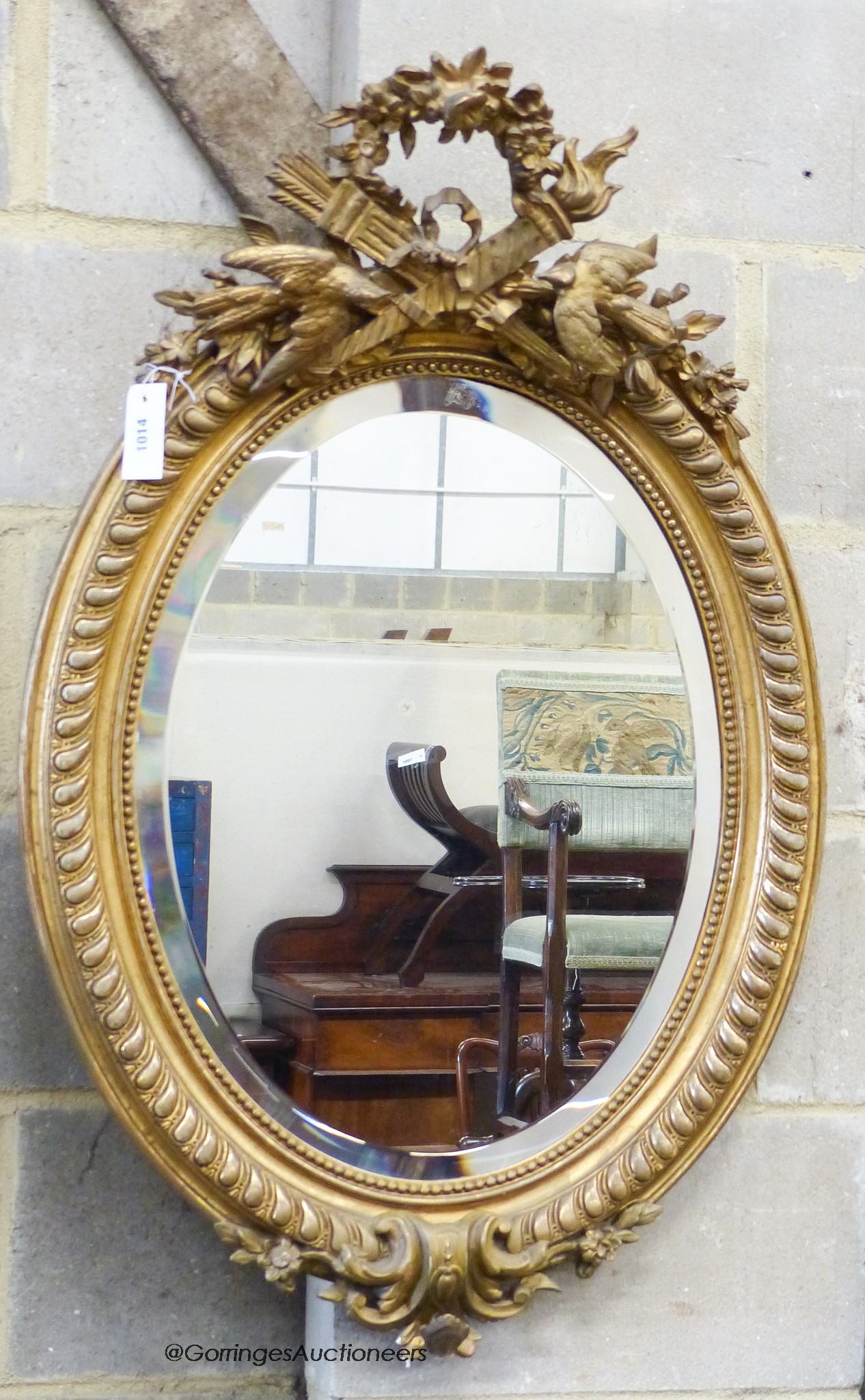A late Victorian, gilt wood and gesso oval wall mirror, with bird pediment, W-63, H-96cm.                                                                                                                                   