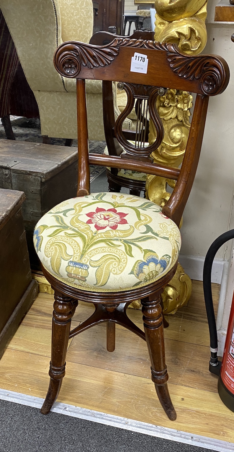 A Regency carved mahogany harpist's chair, with a lyre back and a height adjustable seat, height 84cm                                                                                                                       