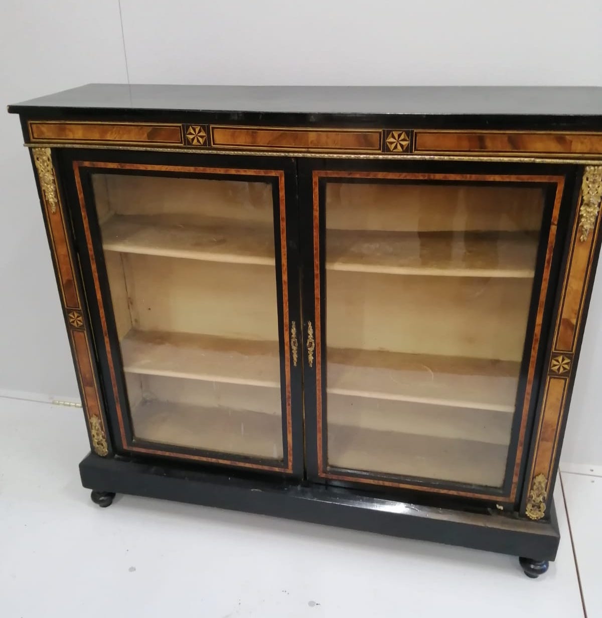 A late Victorian amboyna banded ebonised side cabinet, width 115cm, depth 32cm, height 103cm                                                                                                                                