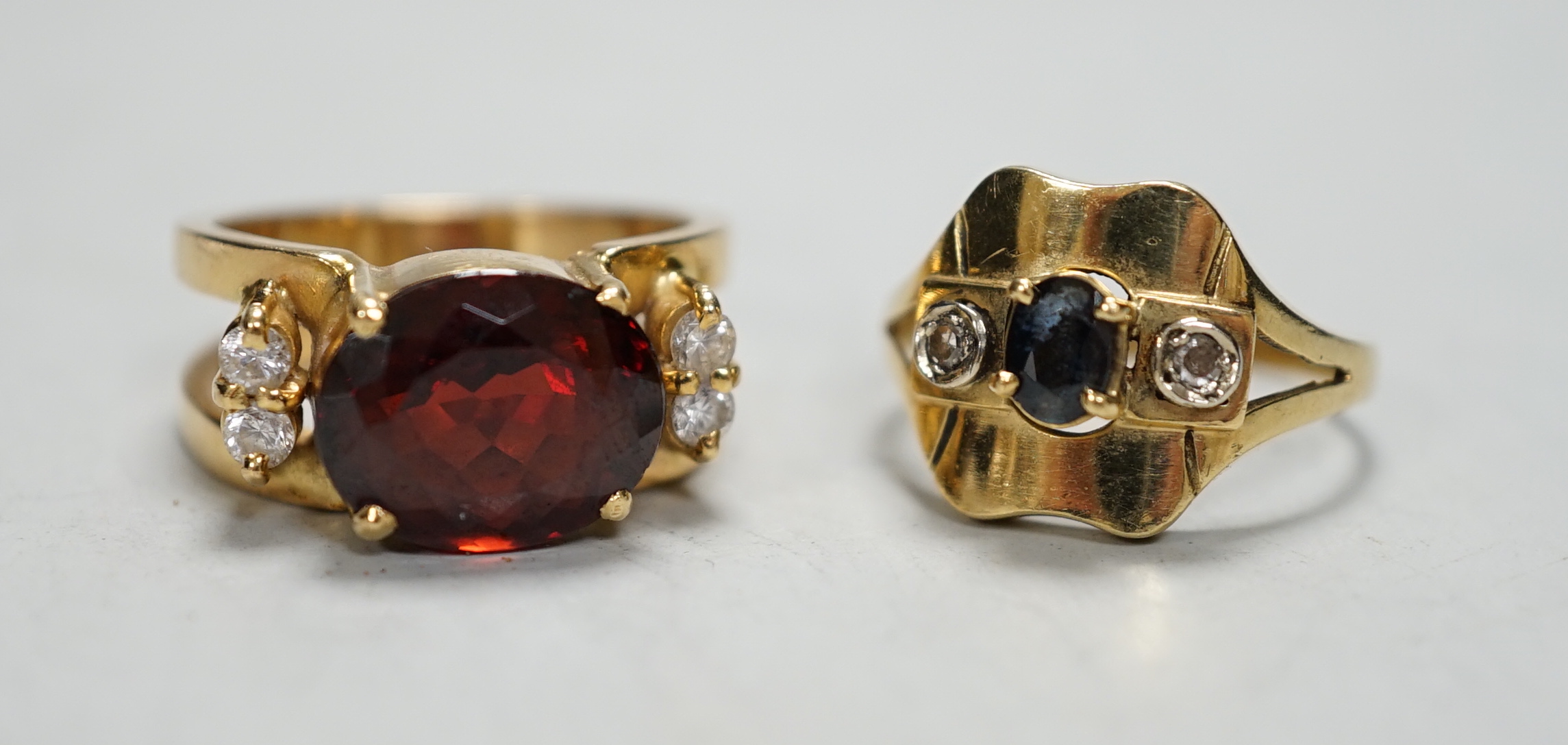 A modern 750, sapphire and diamond chip set three stone ring, size O and one other yellow metal and gem set ring                                                                                                            