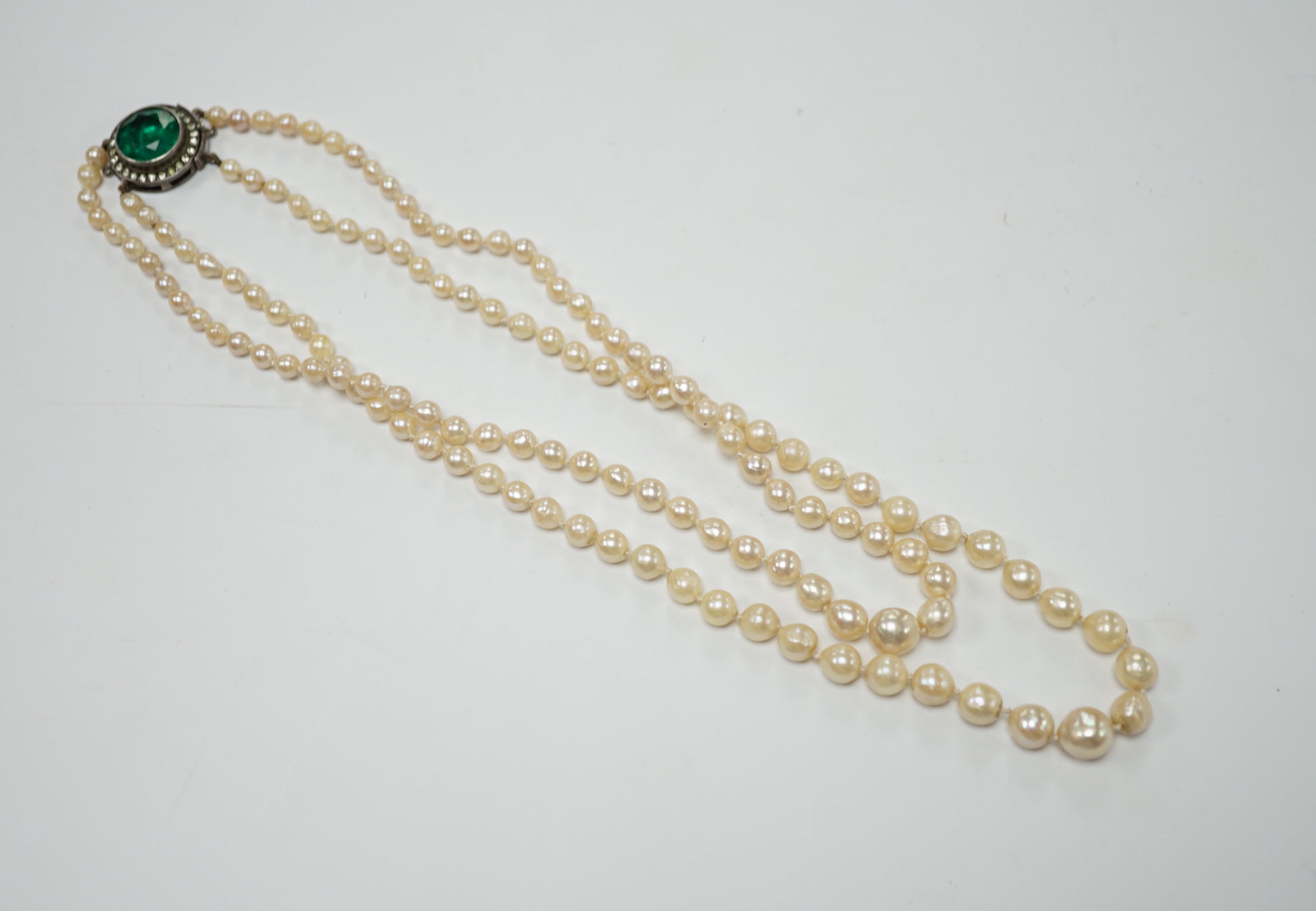 A double strand graduated cultured pearl necklace, with two colour paste set white metal clasp, 39cm.                                                                                                                       