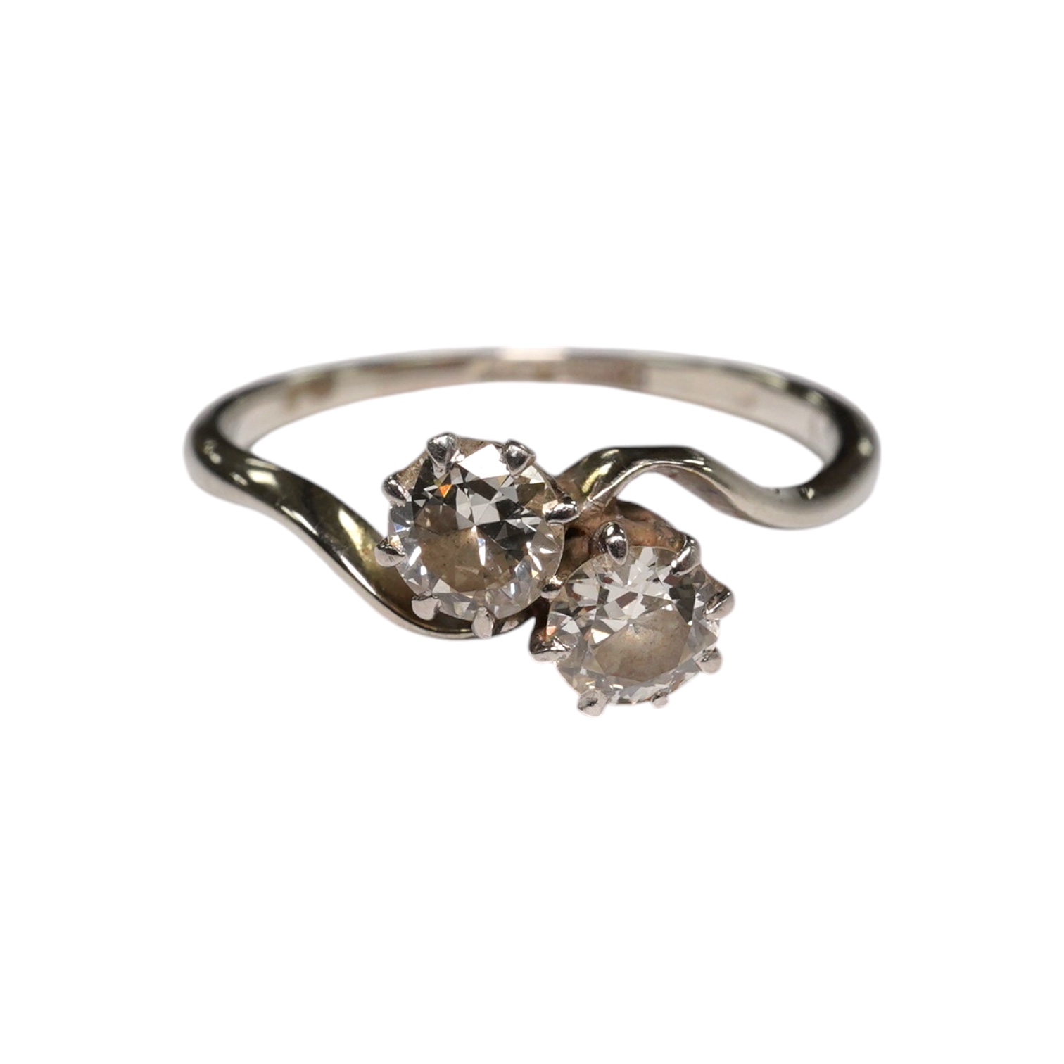 An 18ct, plat and two stone diamond set crossover ring, size O, gross weight 2.3 grams, Condition - fair to good                                                                                                            