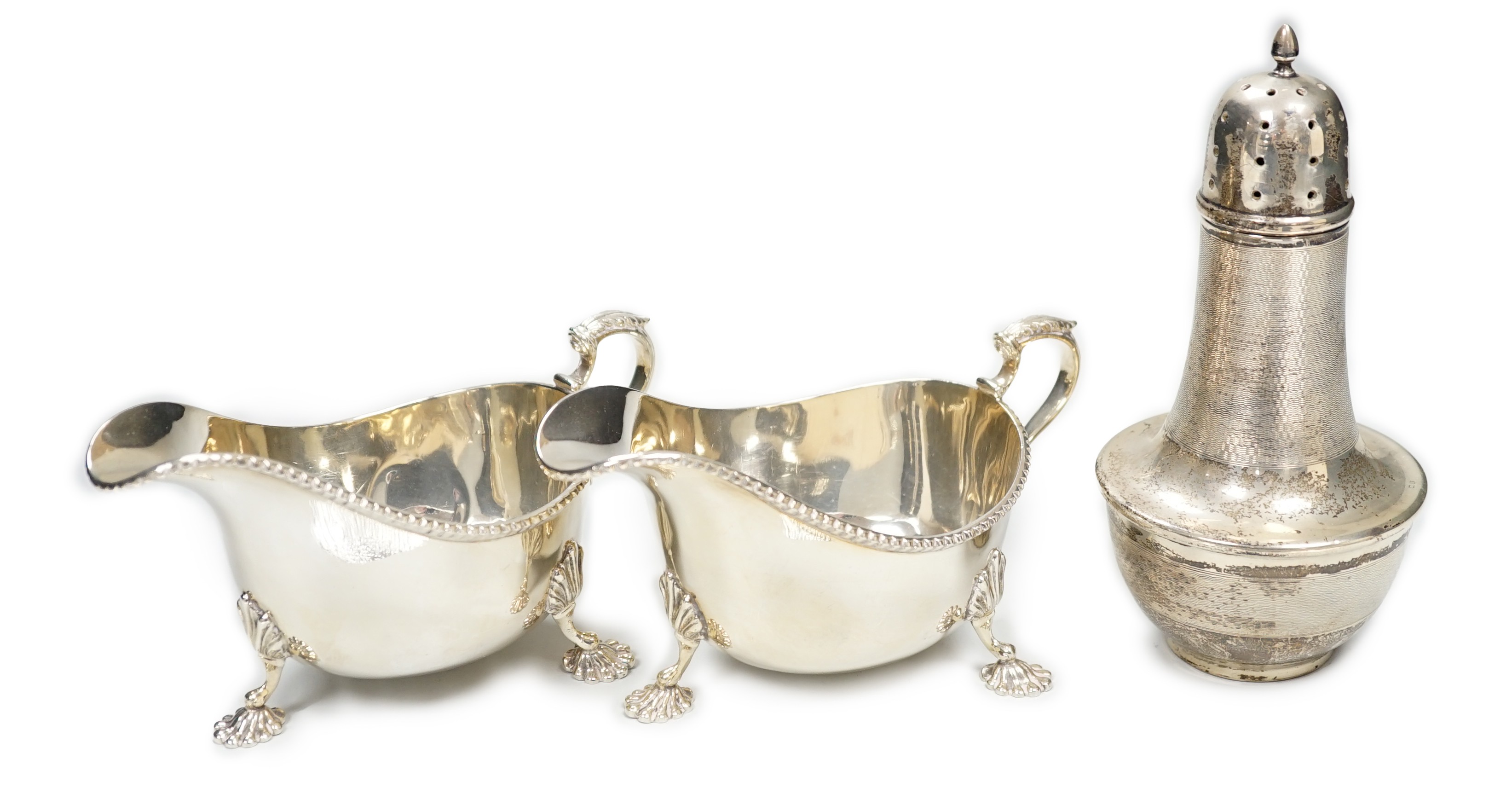 A pair of Elizabeth II silver sauceboats, Adie Bros., Birmingham, 1958 and an earlier engine turned silver sugar caster, gross 13.8oz.                                                                                      