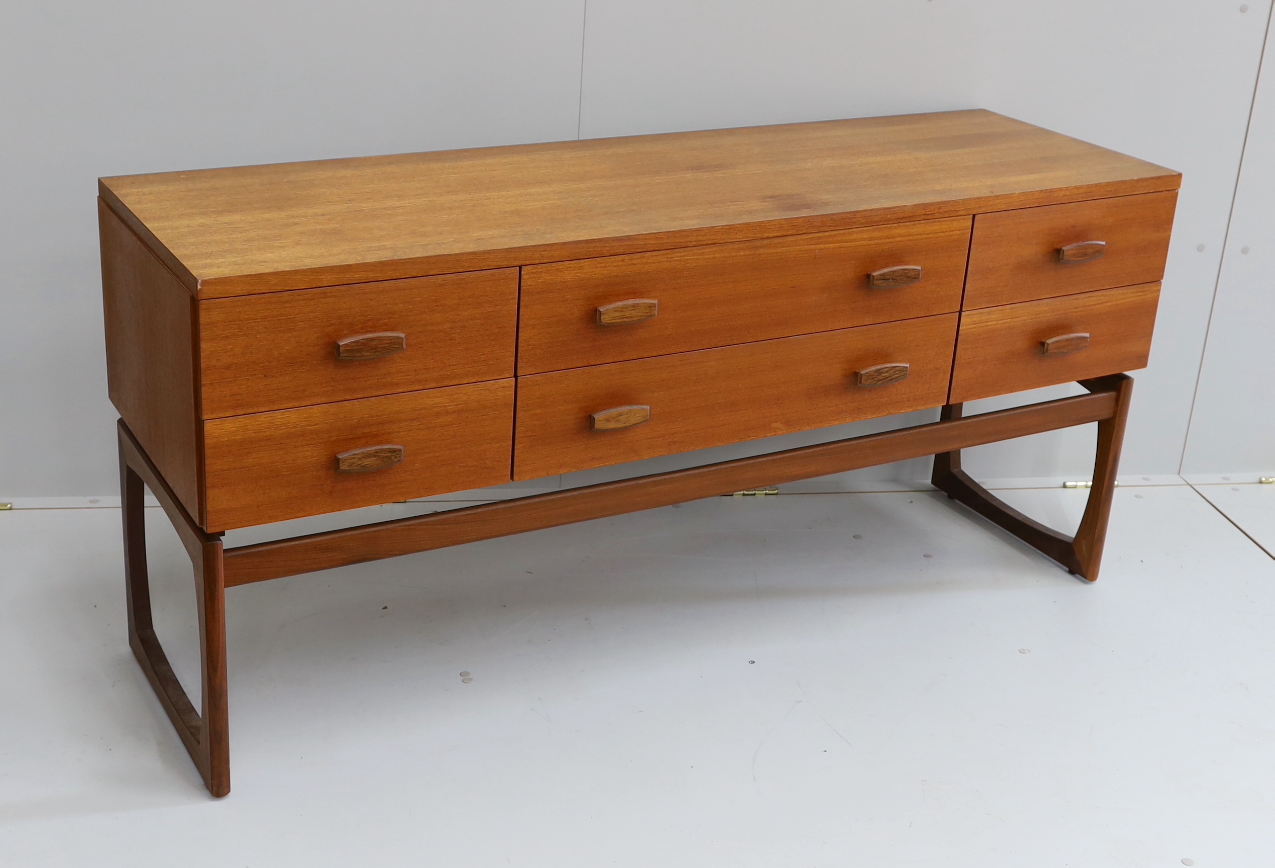 Ib Kofod Larsen for G Plan, a teak six drawer dressing table, length 152cm, depth 46cm, height 71cm (mirror back present but in need of repair)                                                                             