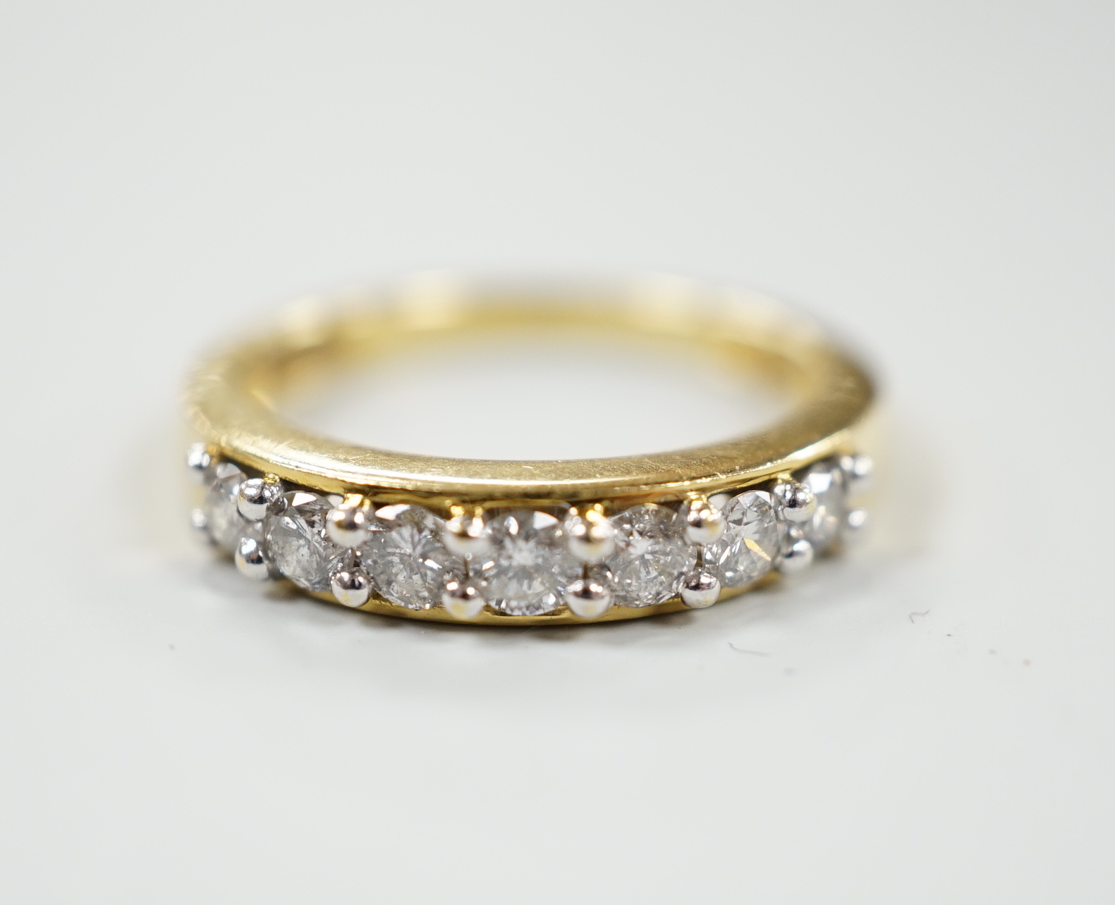 A modern 18ct gold and seven stone diamond set half hoop ring, total carat weight 0.50ct, size J, gross weight 3.4 grams.                                                                                                   