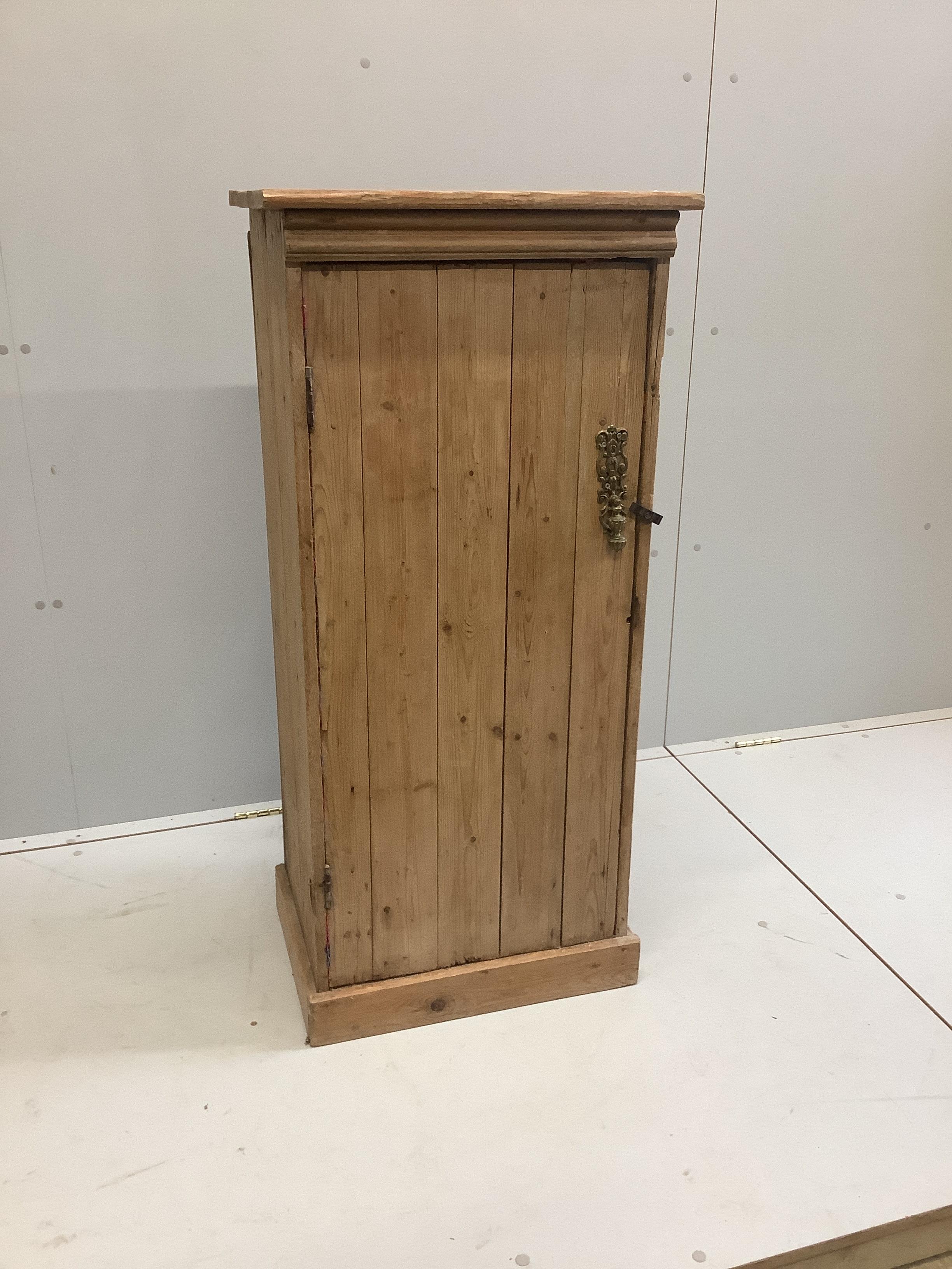 A narrow pine single door cabinet, width 52cm, depth 37cm, height 113cm                                                                                                                                                     