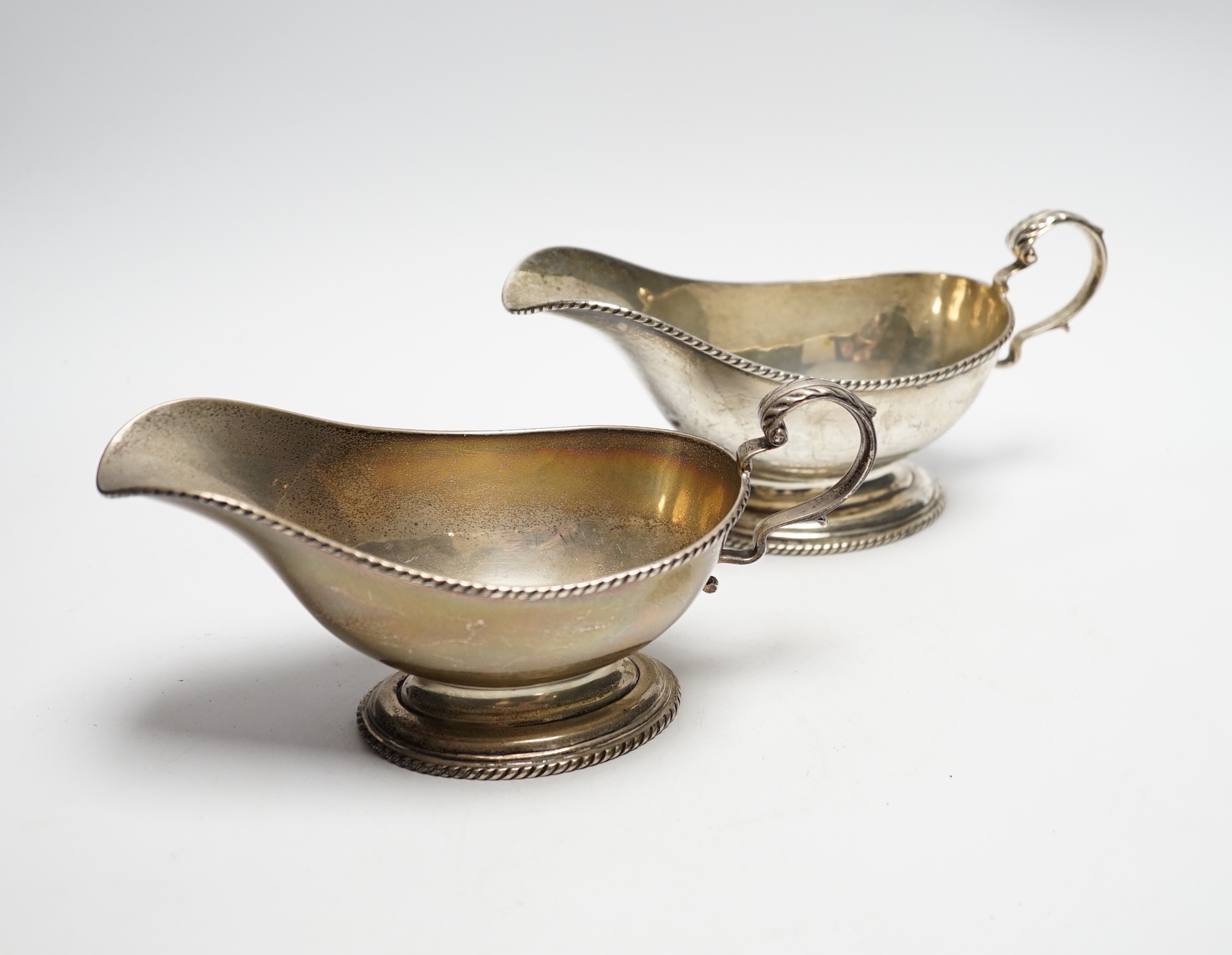 A pair of George V silver oval pedestal sauceboats, London, 1917, 19cm length, 10.6oz.                                                                                                                                      