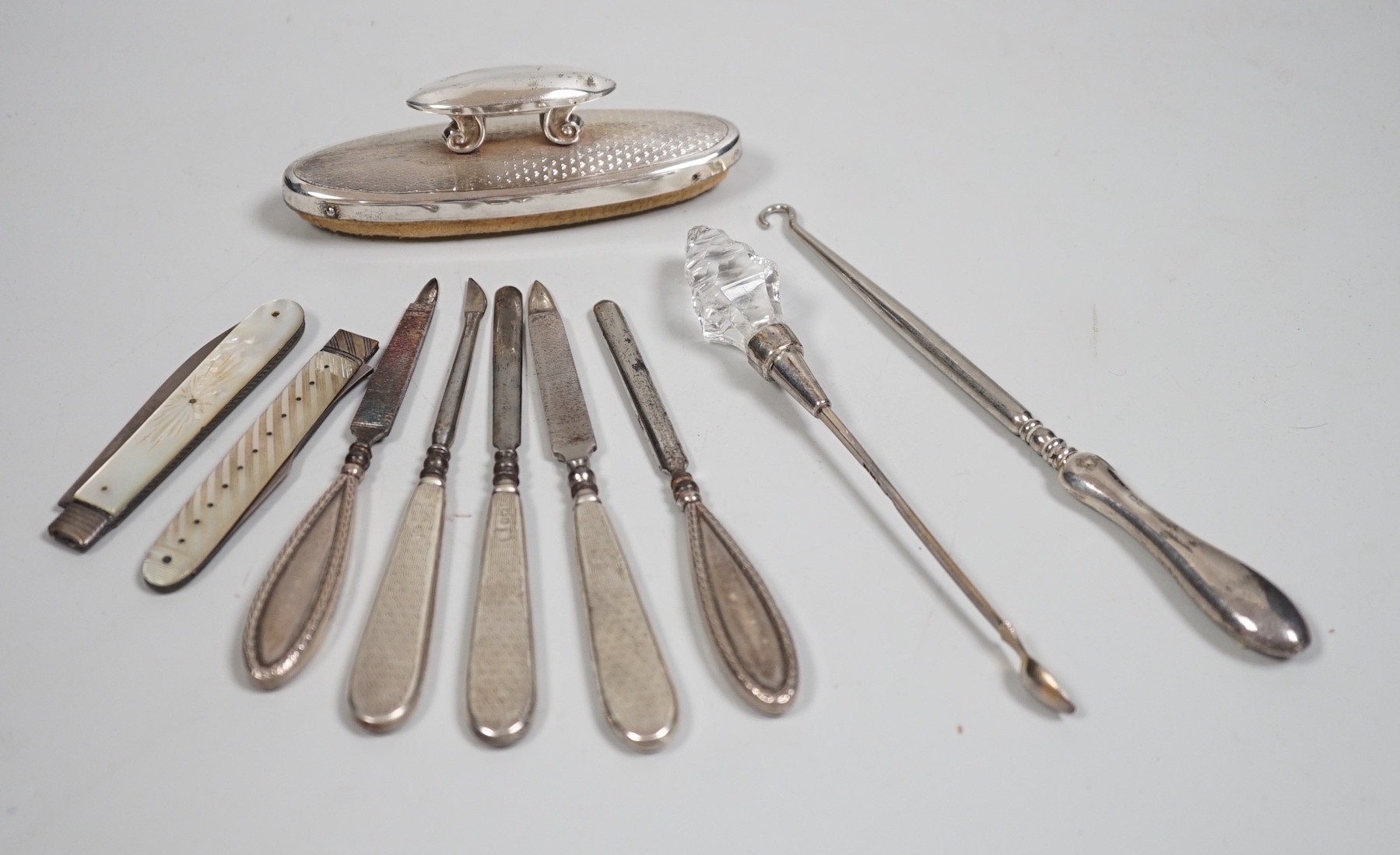 A small group of assorted manicure items and a leather travelling case containing a matched silver and mother of pearl travelling knife and fork.                                                                           