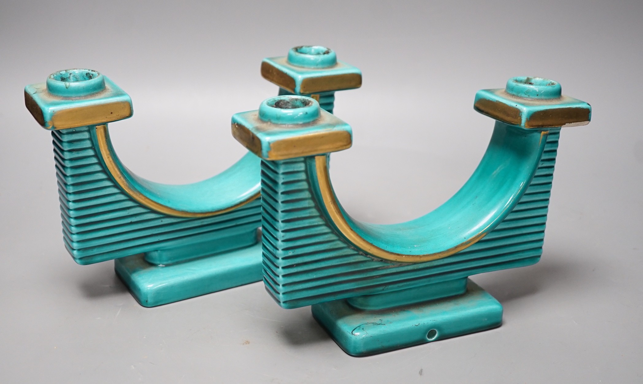 A pair of French turquoise glazed two branch candlesticks, 21.5cm wide                                                                                                                                                      