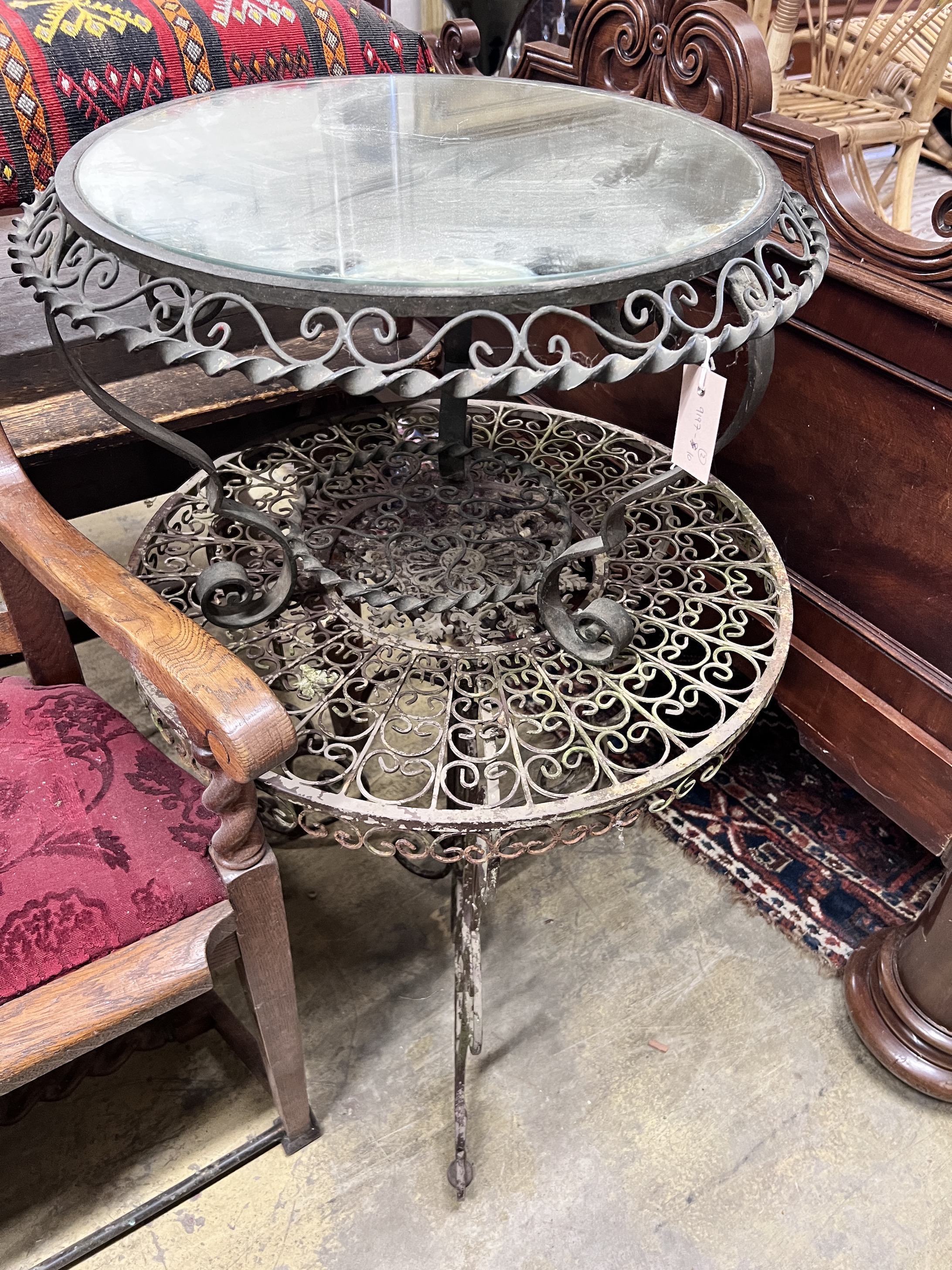 A wrought iron garden table, diameter 69cm and a similar low table with mirrored top, diameter 63cm                                                                                                                         