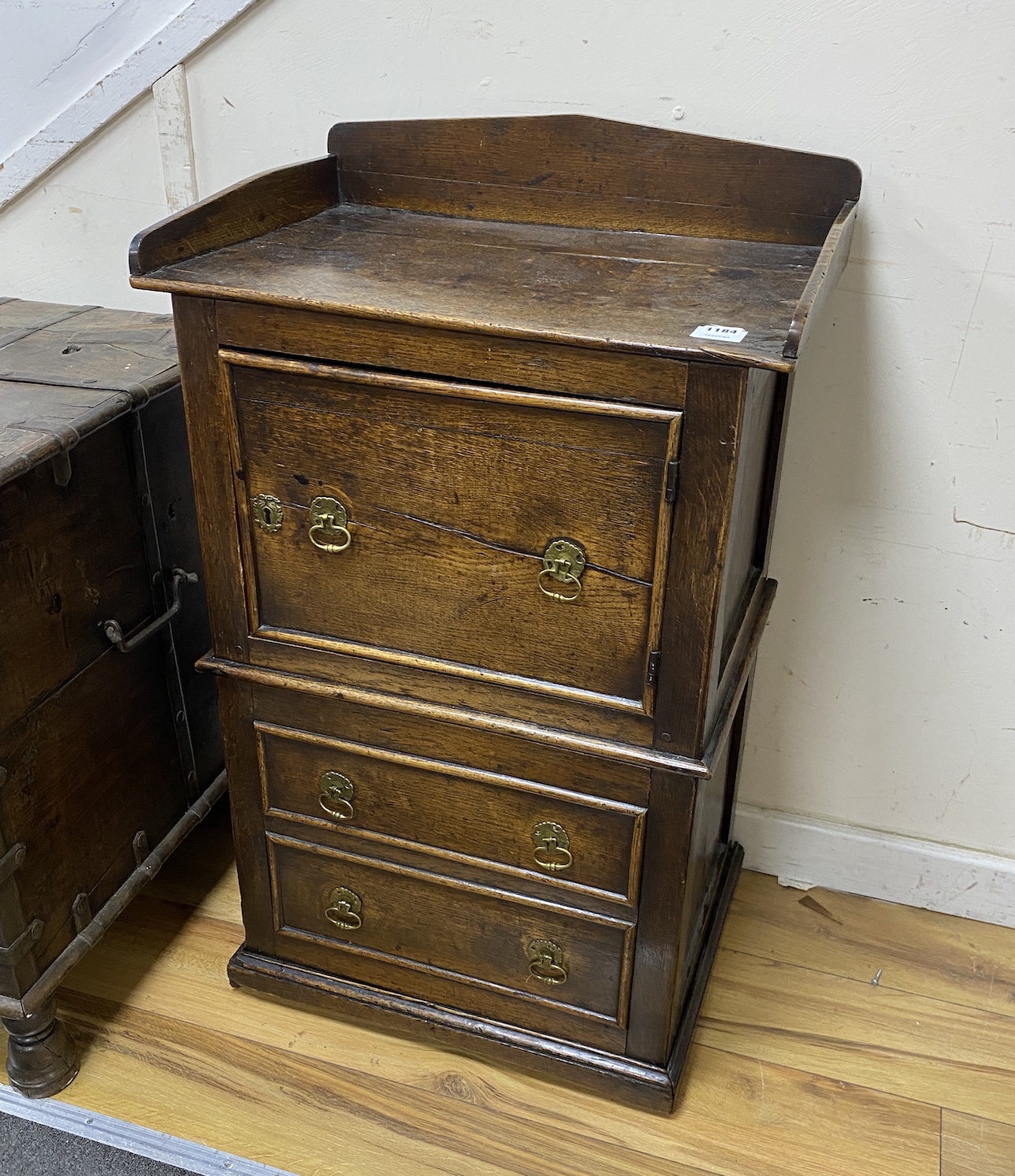 An 18th century oak wash stand, fitted with a cupboard, over a pull out base, with brass axe drop handles, width 59cm, depth 41cm, height 86cm                                                                              