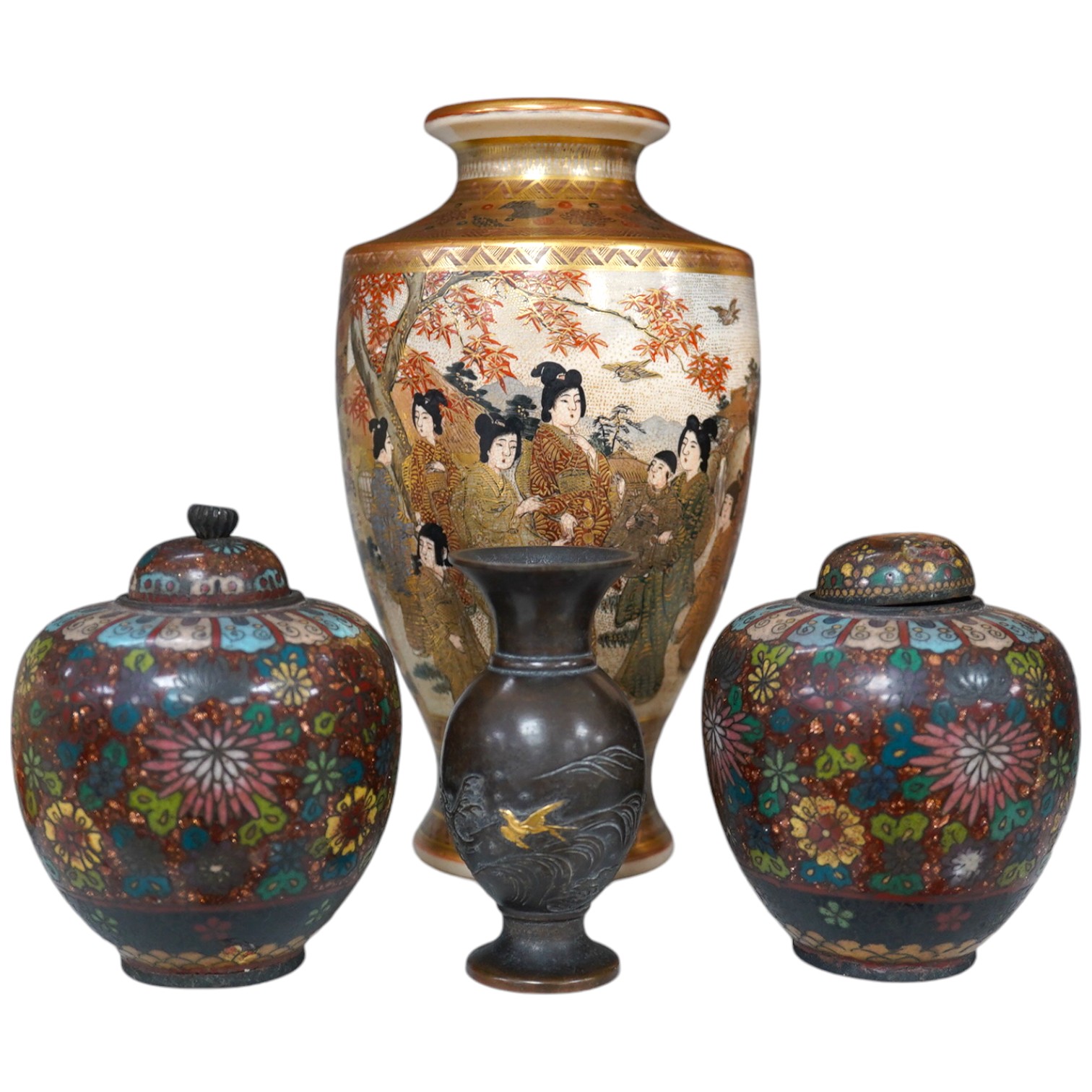 A pair of Japanese cloisonné enamel jars and covers, a Japanese bronze and gold overlaid small vase and a Satsuma pottery vase, tallest 22cm high (4). Condition - finial loose and one missing on cloisonné jars and covers