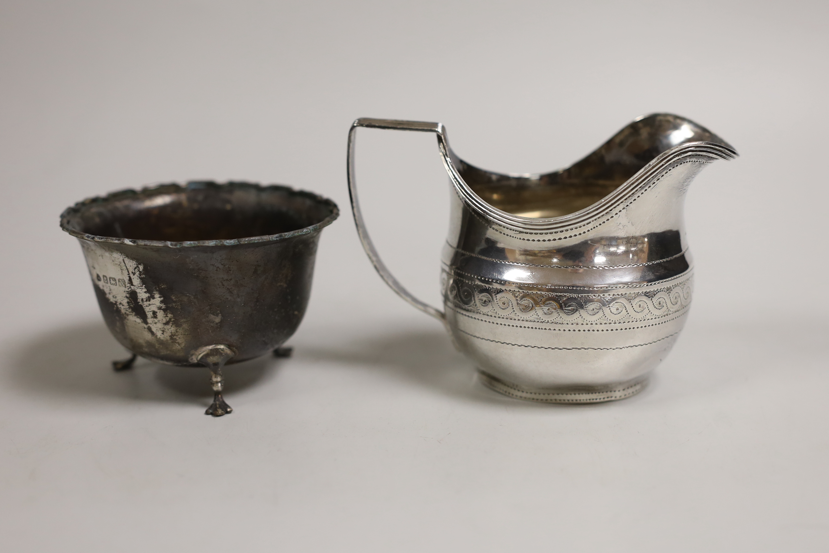 A George III chased silver cream jug, James Mince, London, 1809, 81mm and a later silver sugar bowl, 4.4oz.                                                                                                                 