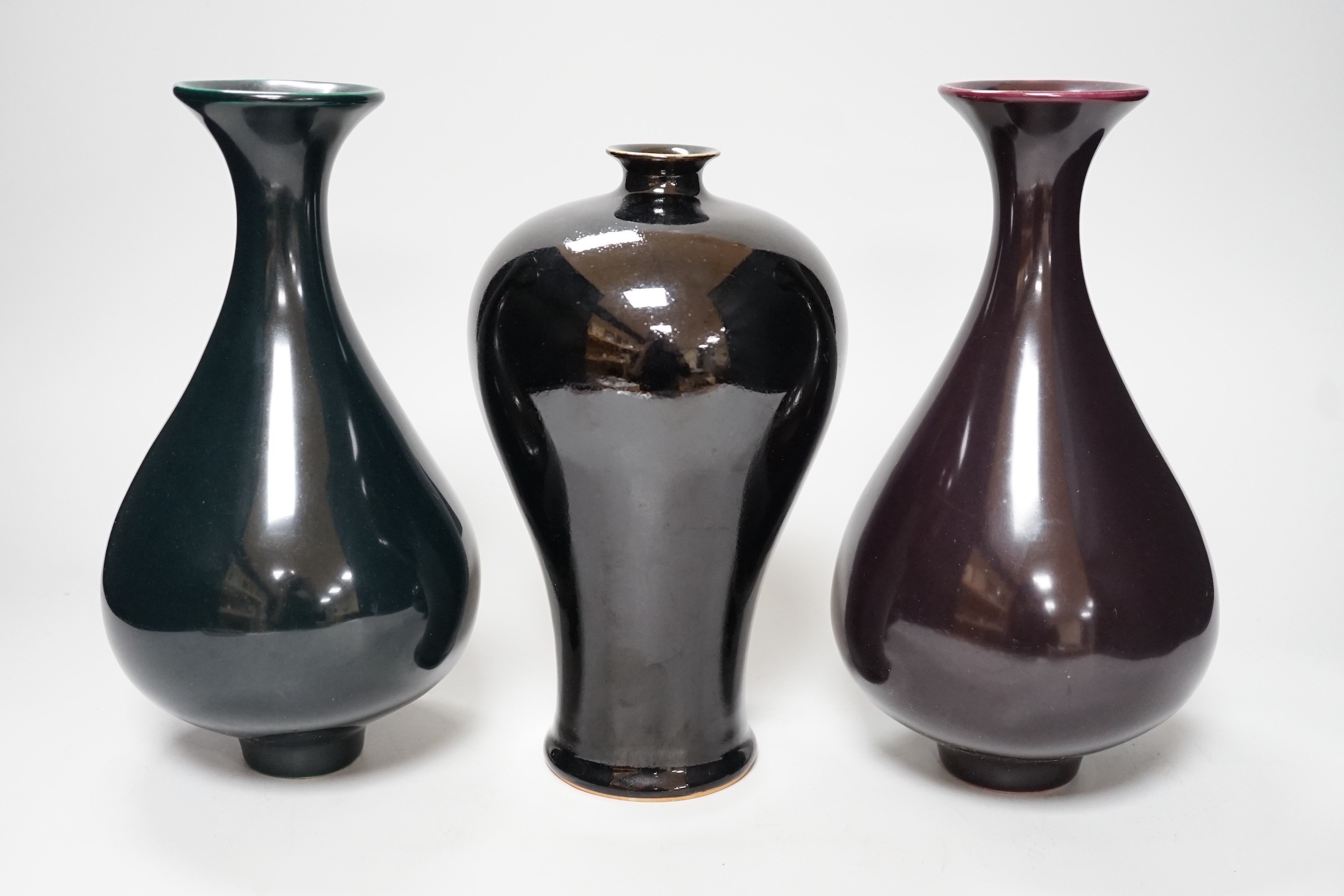 A Chinese black ground plum vase, together with a near pair of Chinese vases, tallest 24cm                                                                                                                                  
