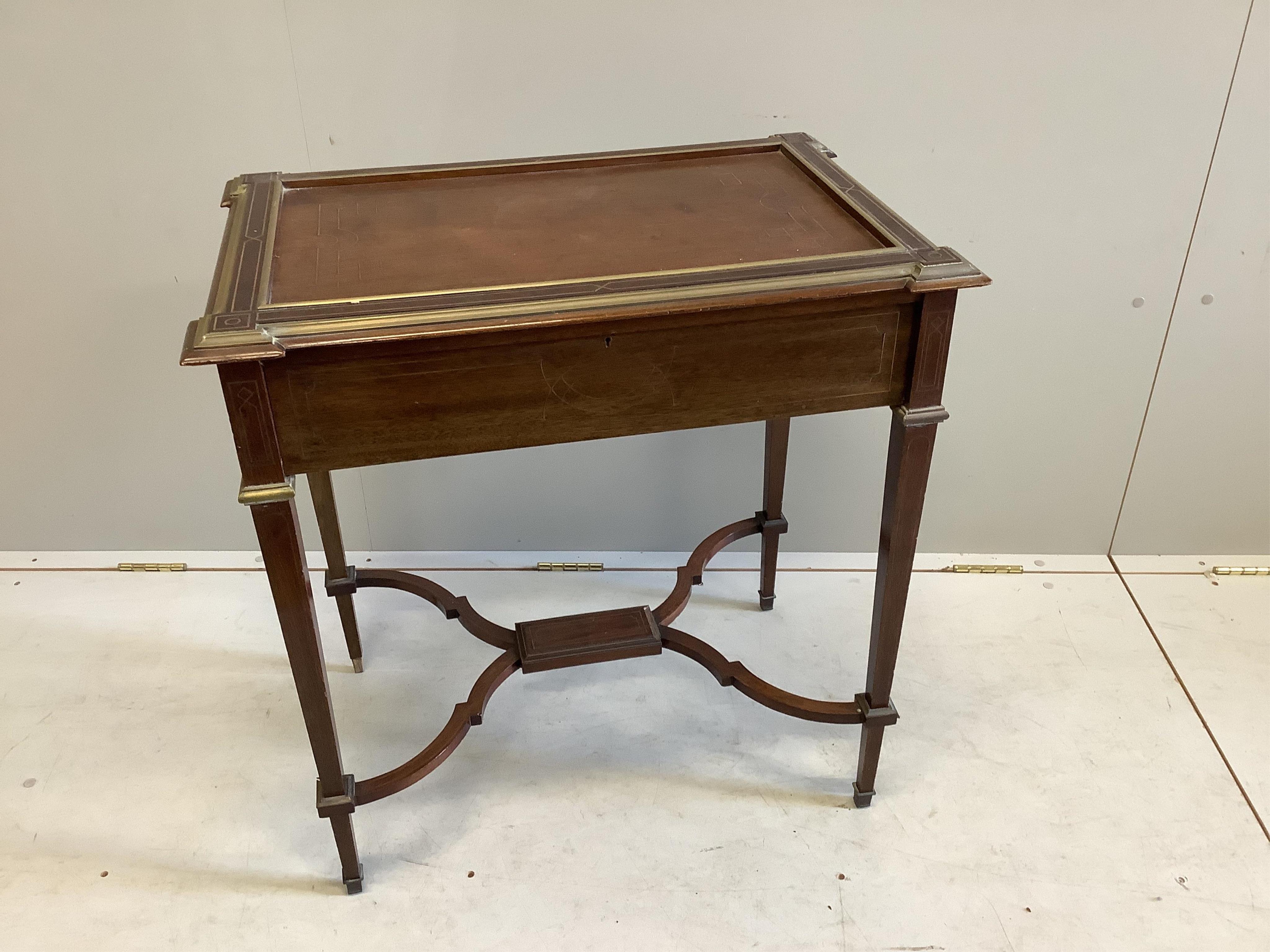 A 19th century French Empire mahogany writing table with gilt brass inlay, frieze drawer with fitted interior and twin pull-out candle slides, on square tapered legs and cross stretchers, width 71cm, depth 47cm, height 7