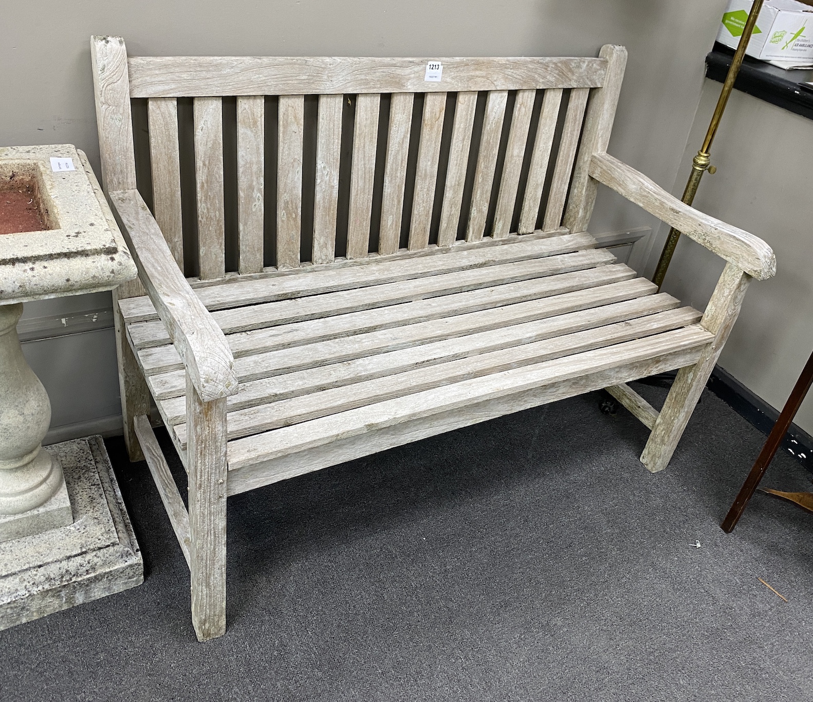 A weathered slatted teak garden bench, length 120cm, depth 56cm, height 89cm                                                                                                                                                