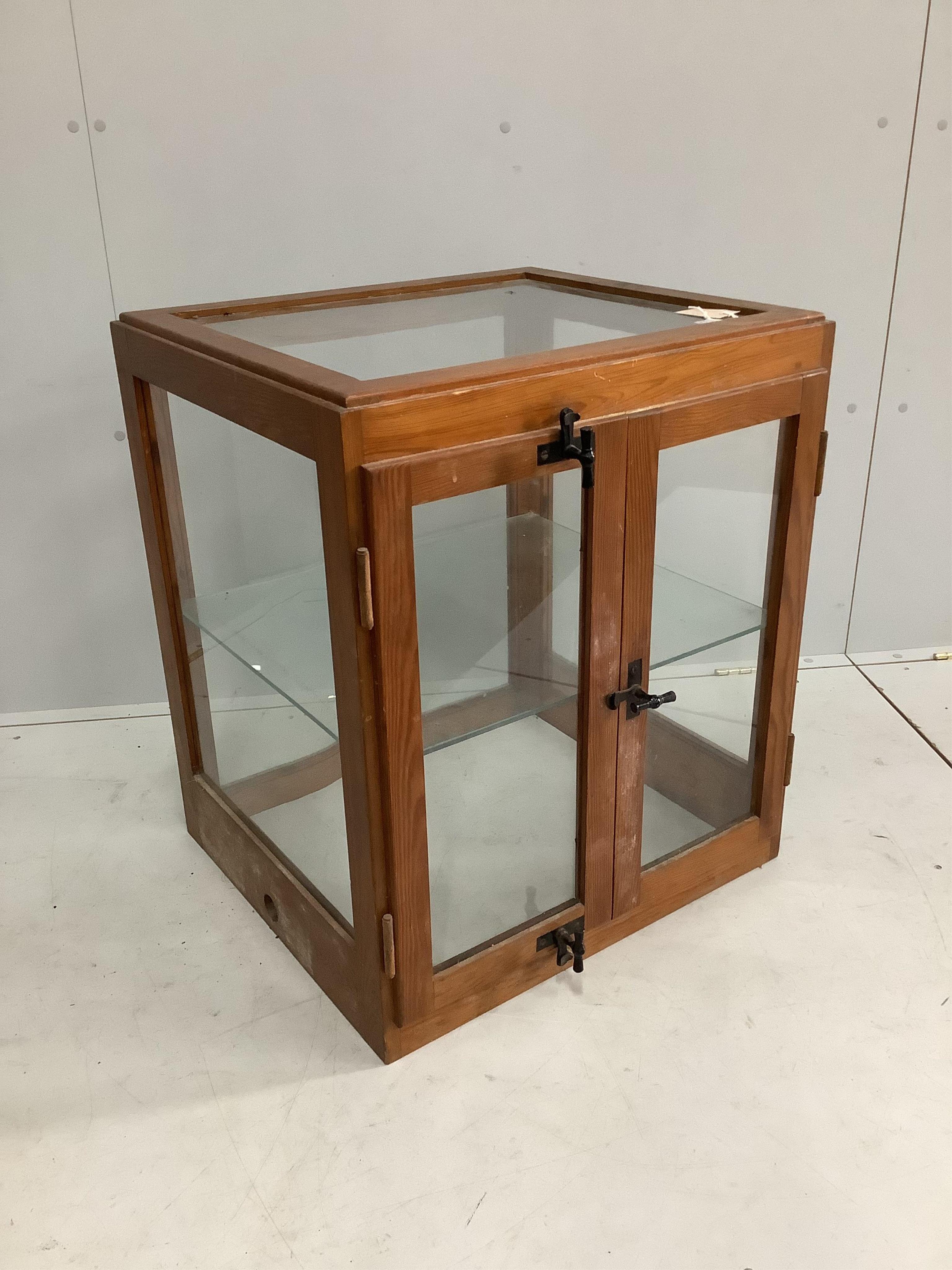 A mid 20th century glazed pine counter cabinet, width 62cm, depth 55cm, height 72cm. Condition - fair to good                                                                                                               