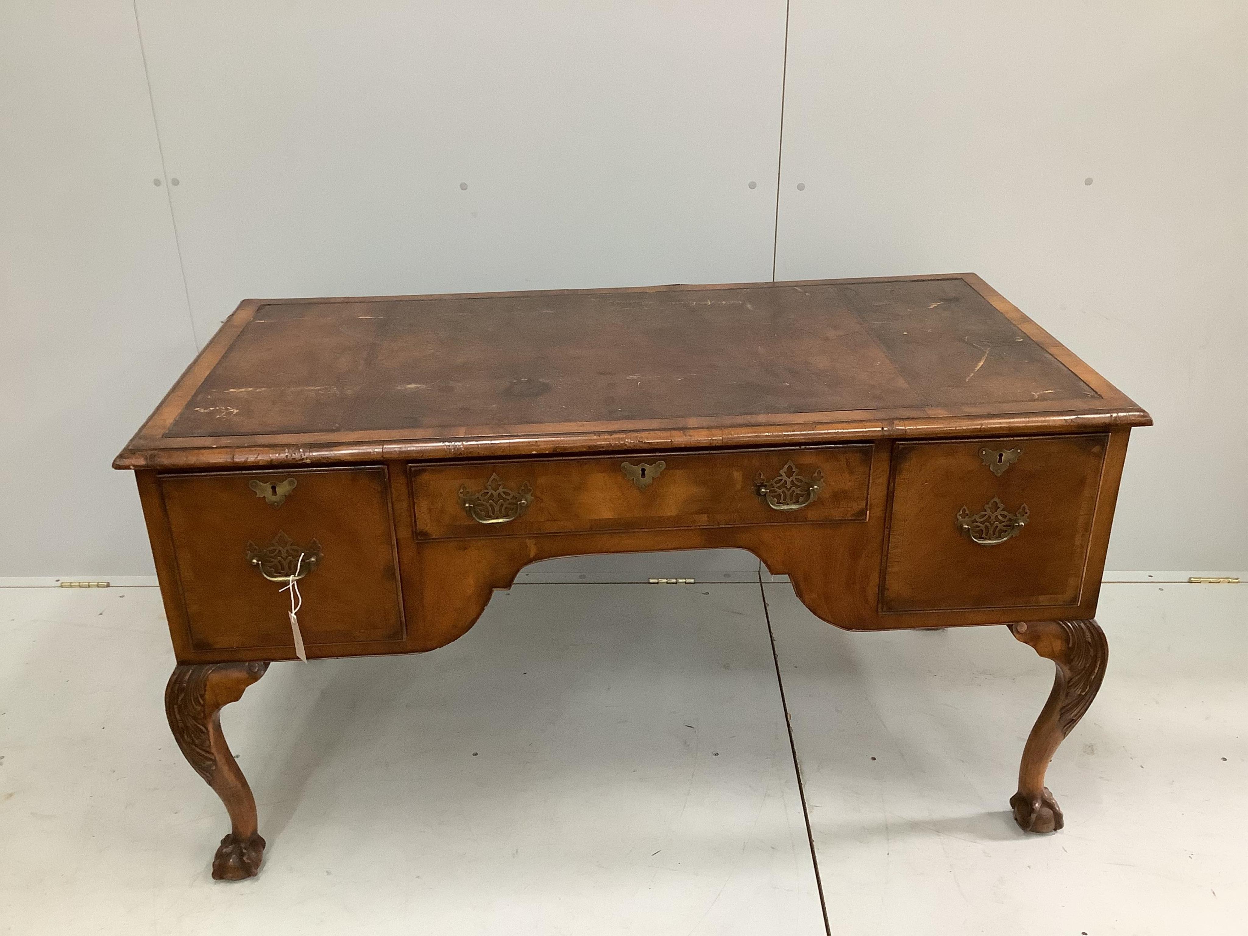 A 1930's walnut kneehole walnut writing table, width 148cm, depth 68cm, height 76cm. Condition - fair to good                                                                                                               