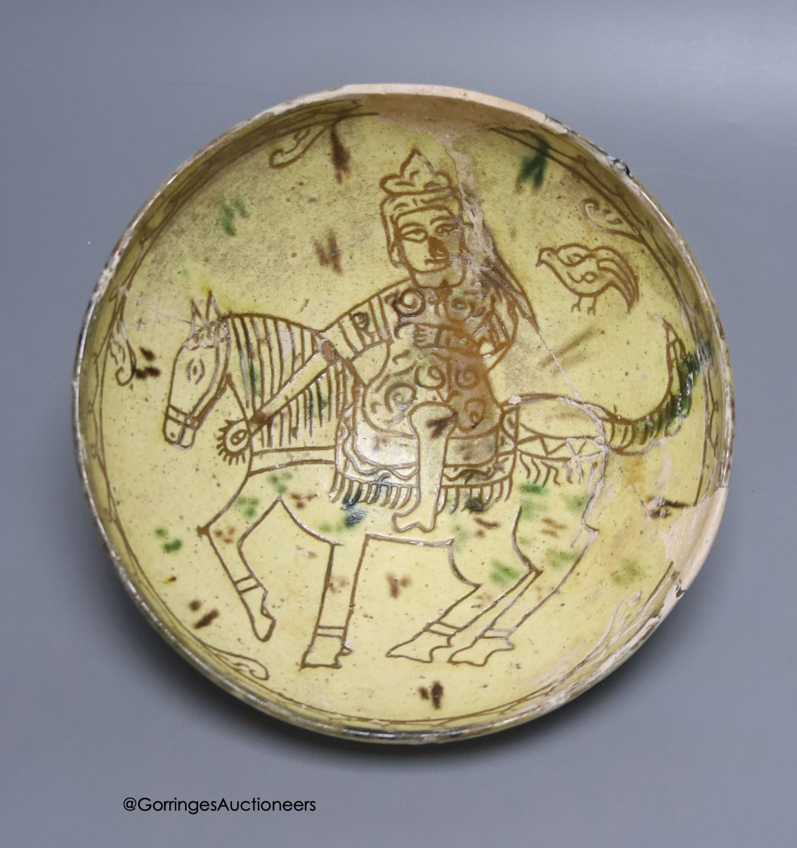 An Islamic pottery bowl decorated with a figure on horseback, diameter 23cm (a.f.)                                                                                                                                          