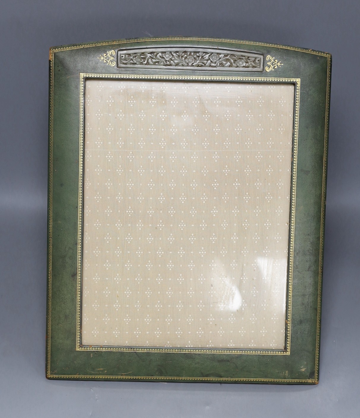 An early 20th century tooled photograph frame with inset Chinese pierced bowenite jade panel, 43cm tall                                                                                                                     