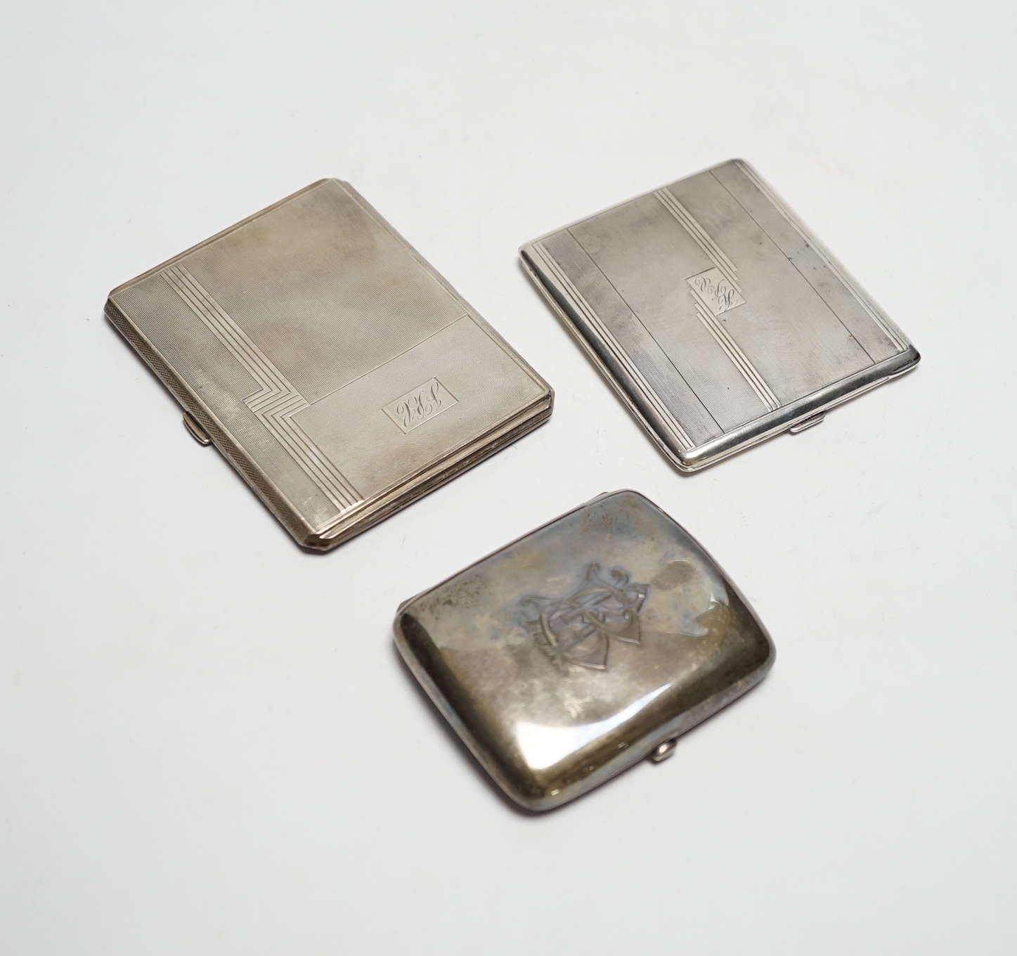 Three silver cigarette cases, including two Art Deco, largest 11.4cm.                                                                                                                                                       