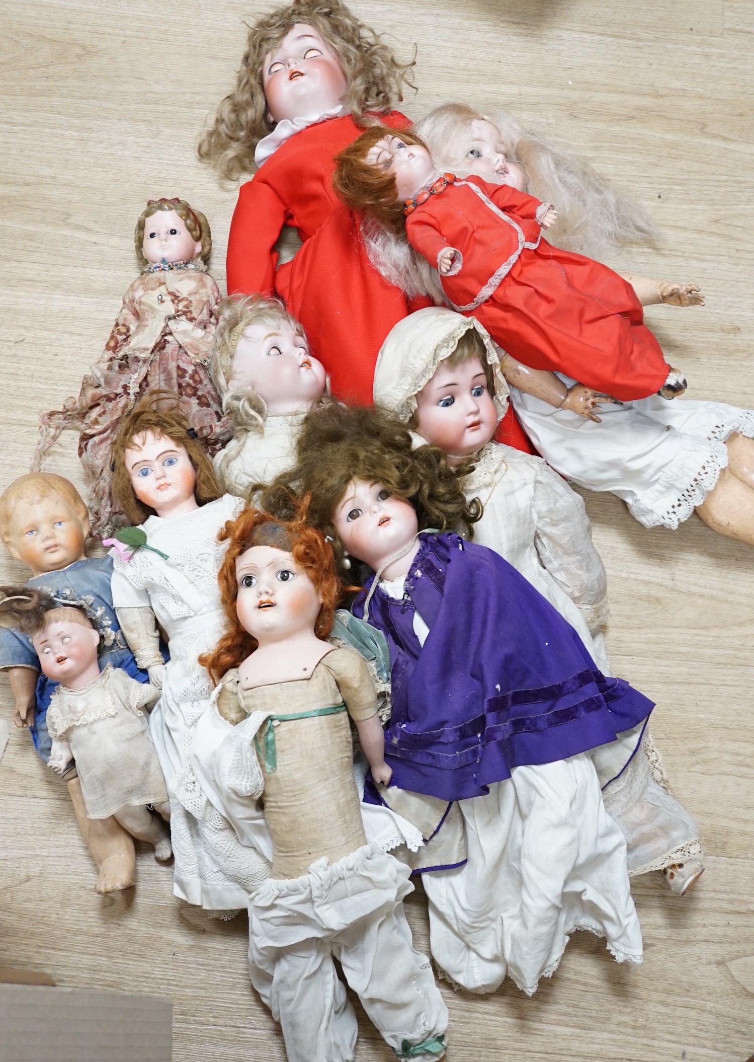 Two Kammer and Reinhardt bisque headed dolls, a wax over composition doll, various other bisque headed dolls and a few single heads and a collection of miniature dolls                                                     