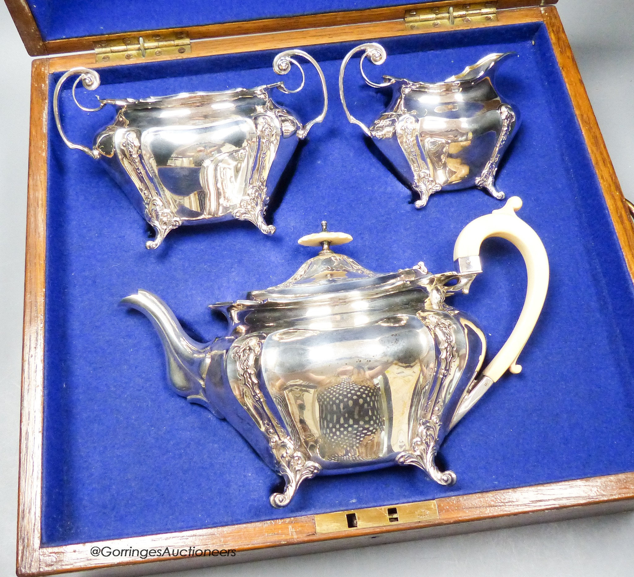 An oak cased Edwardian silver three piece tea set, James Dixon & Sons, Sheffield, 1904, gross weight 33oz.                                                                                                                  