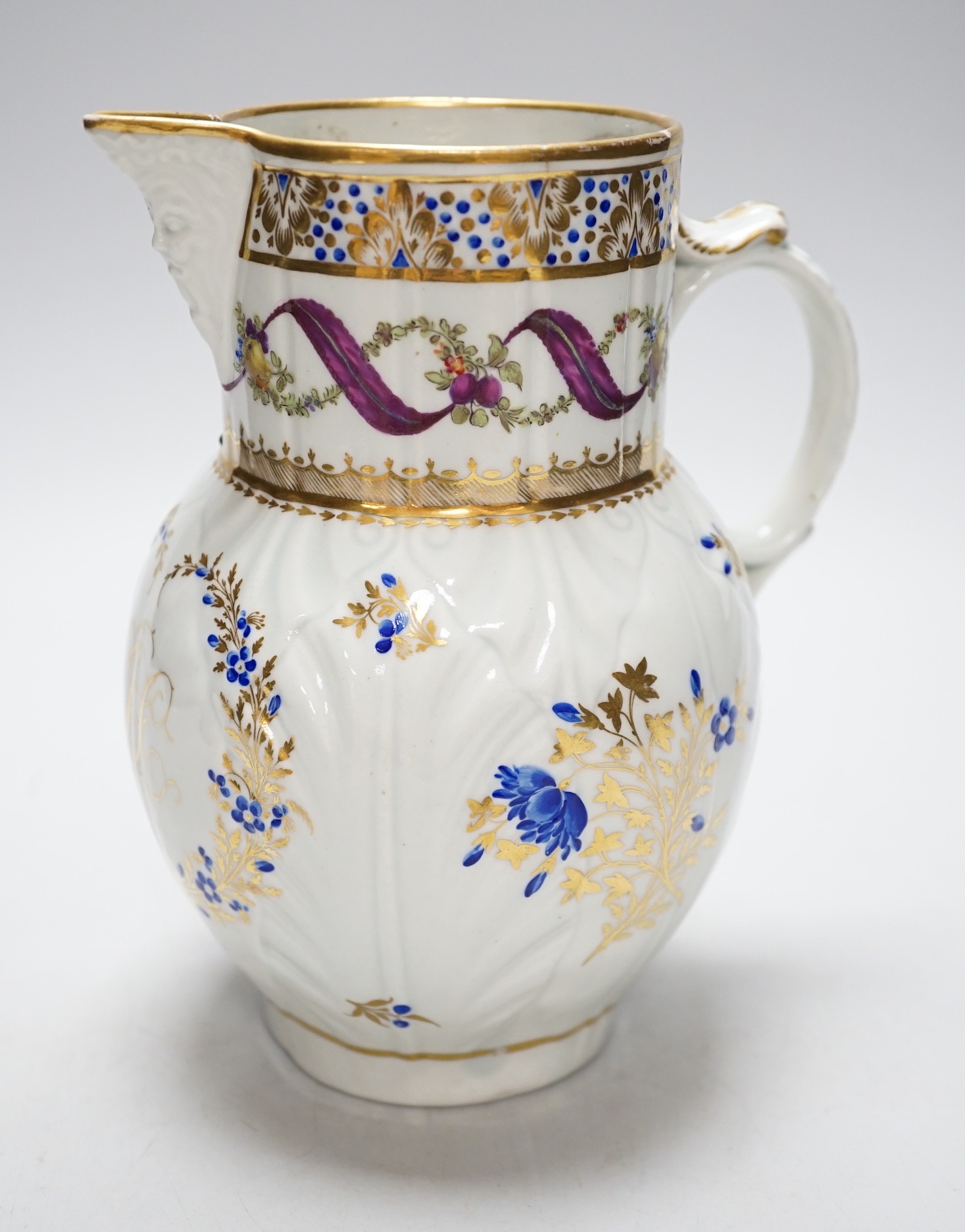 An 18th century Caughley very rare polychrome mask jug, elaboratley painted and gilded with two initials in a dry blue and gilt wreath, Gittins Col., Pictured Caughley Bicentenary Exhibition 1999, with labels, 19cms high