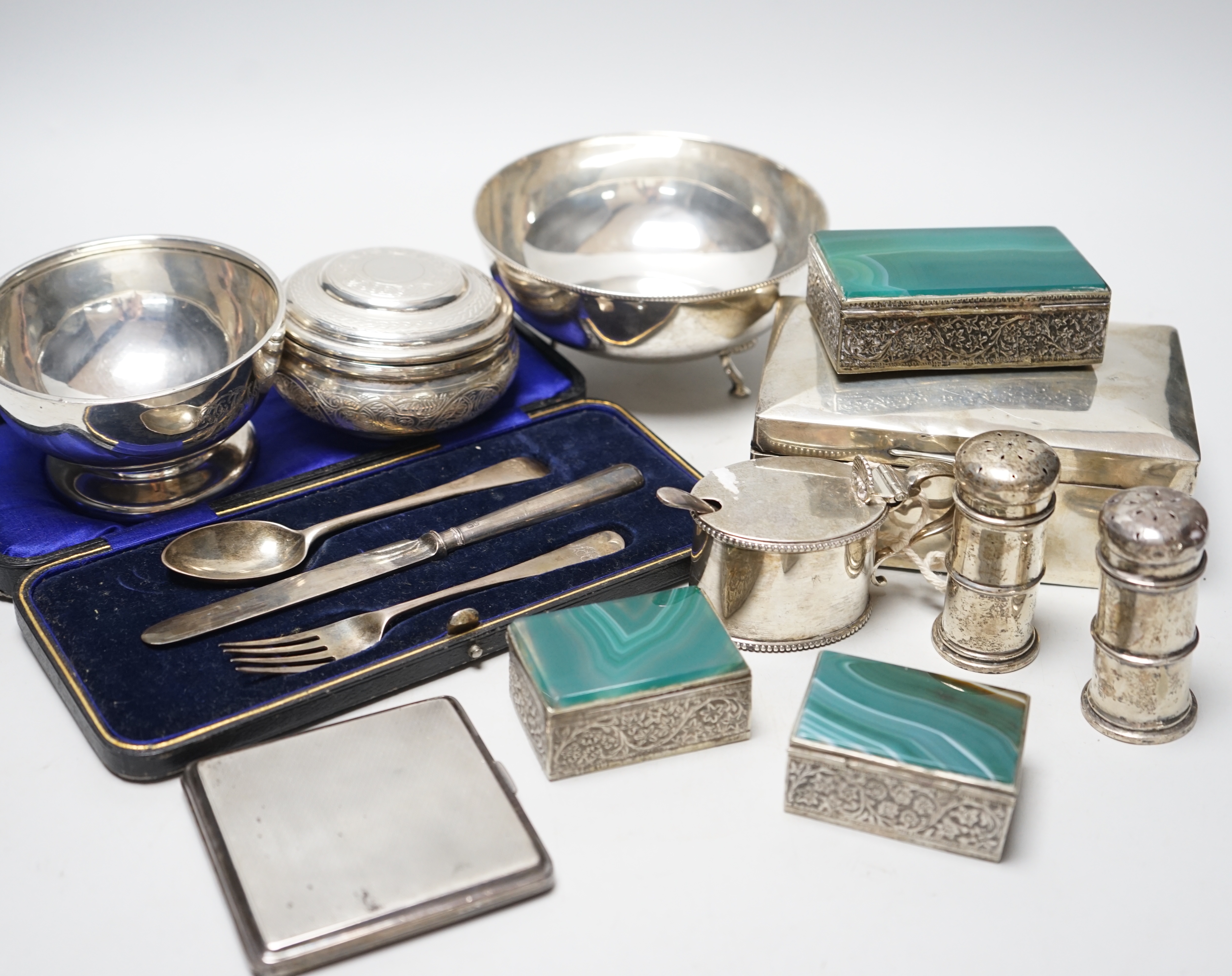 A small mixed collection of silver to include a cigarette box, together with an .830 standard marked white metal tripod bowl, an Eastern white metal box and cover of circular form, a small silver footed bowl, a cased chr