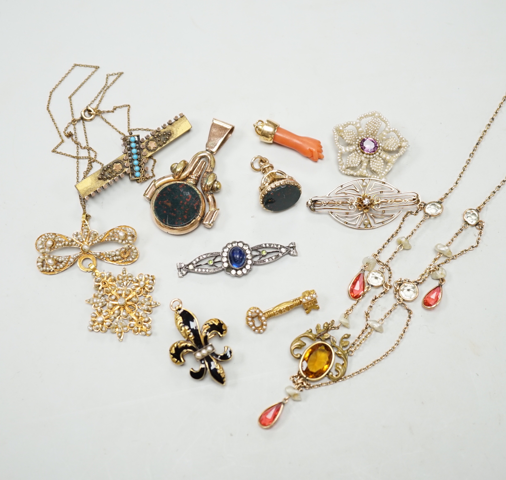 A small group of antique and later jewellery, including 9ct gold and bloodstone fob seal, a 1930's yellow metal and seed pearl set key brooch, 14k and black enamel brooch, spinning fob pendant, coral hand charm, 10k and 