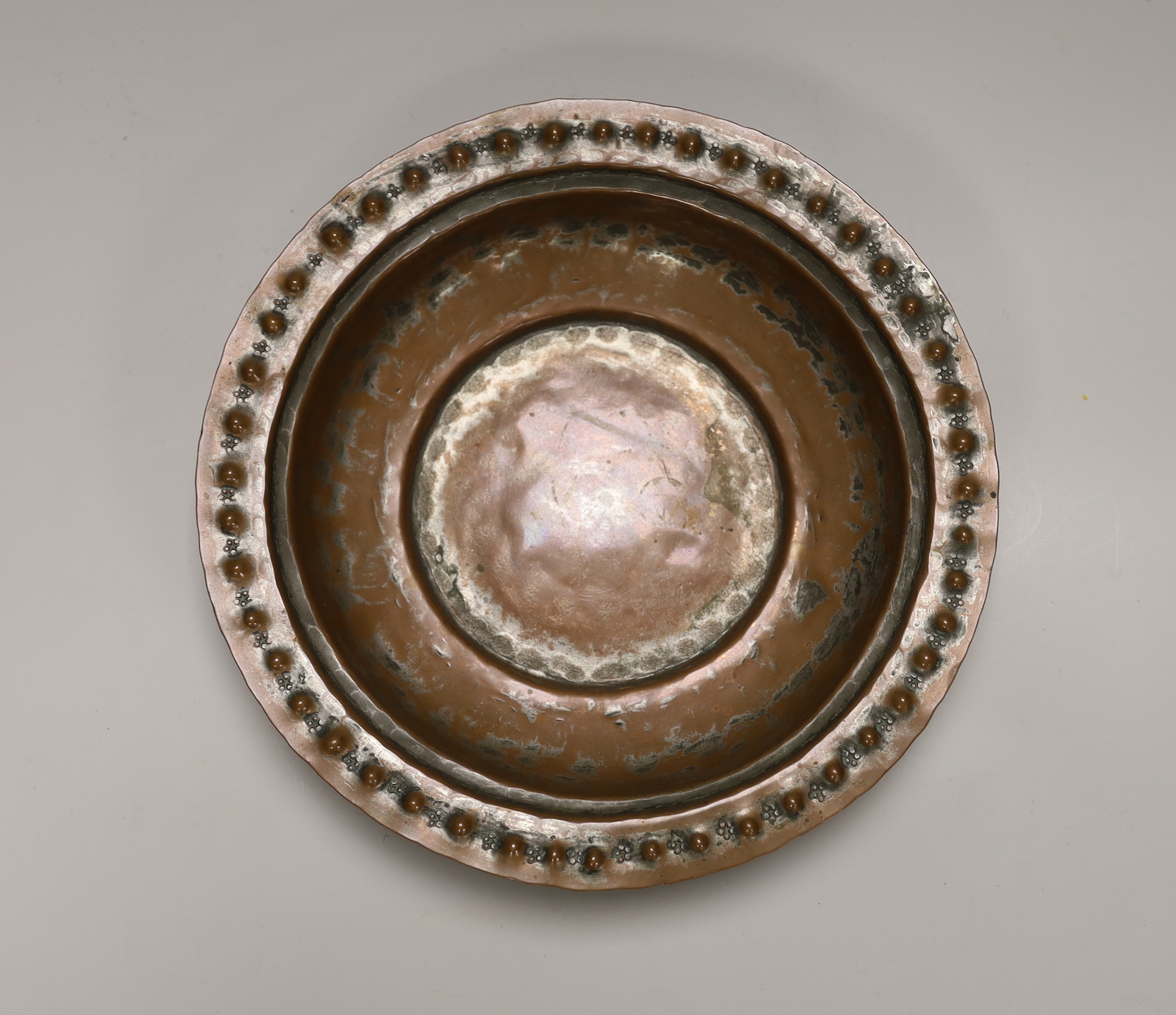 A Middle Eastern tinned copper bowl with embossed rim, 24cm in diameter                                                                                                                                                     