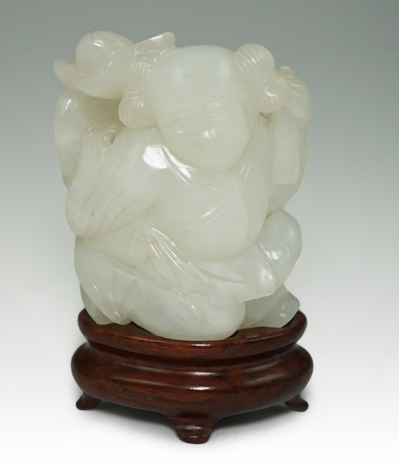 A Chinese white jade figure of a kneeling boy holding lingzhi fungus, 19th century                                                                                                                                          