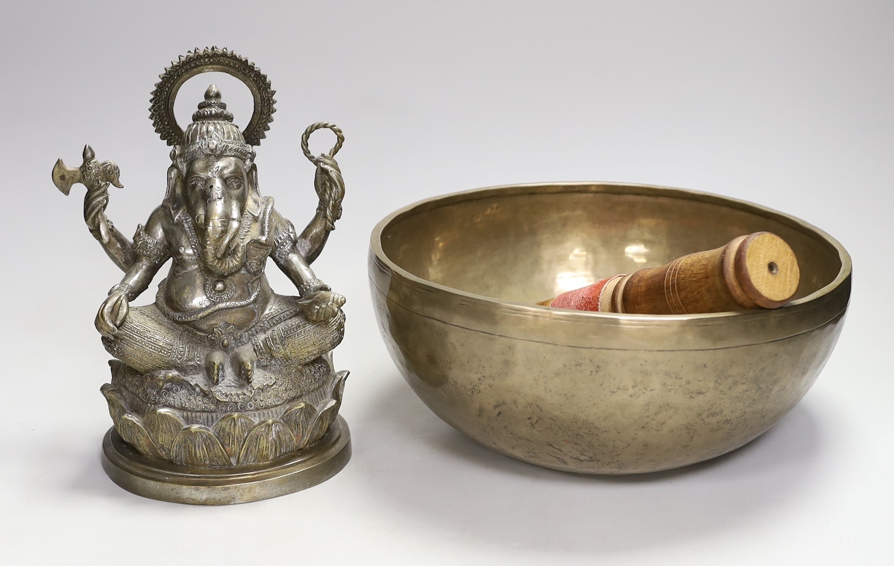 A plated figure of Ganesha and a Tibetan singing bowl with striker                                                                                                                                                          