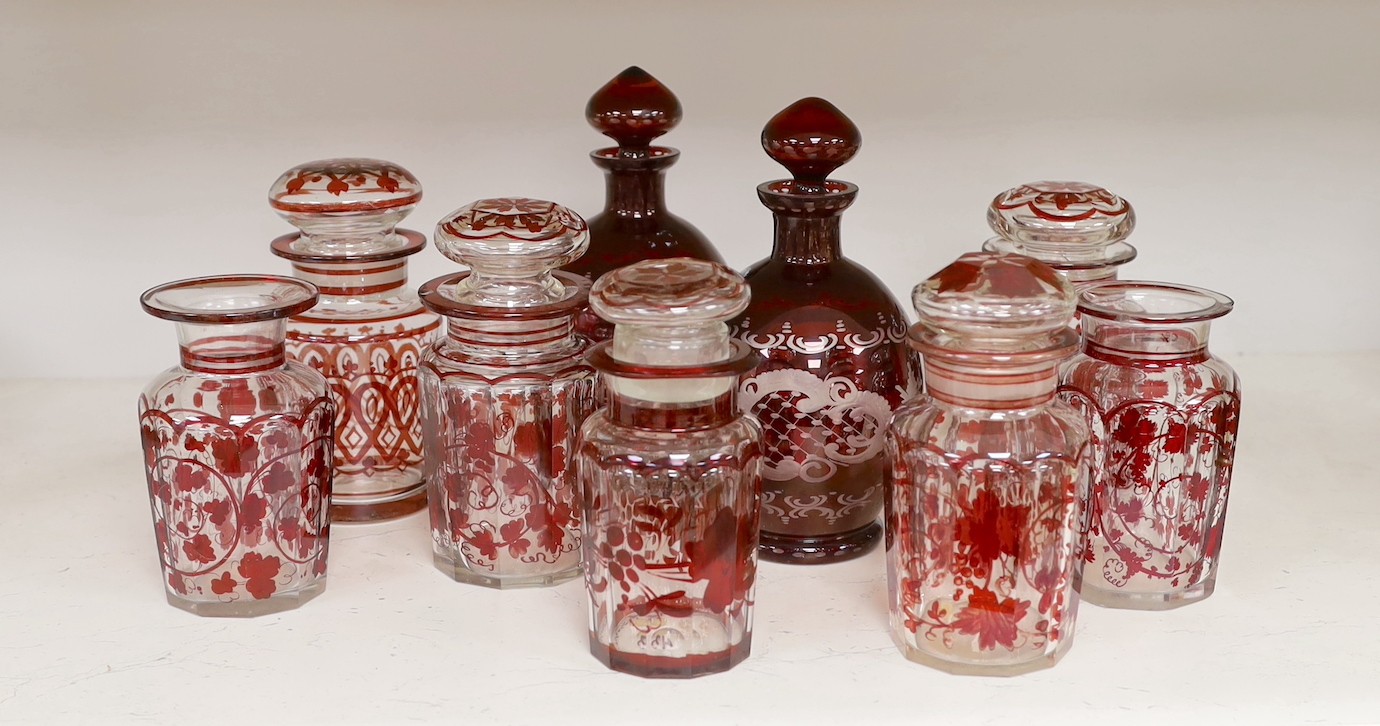 A pair of 19th century wheel engraved ruby glass decanters with stoppers, and seven ruby stained glass jars, tallest 21cm (9)                                                                                               