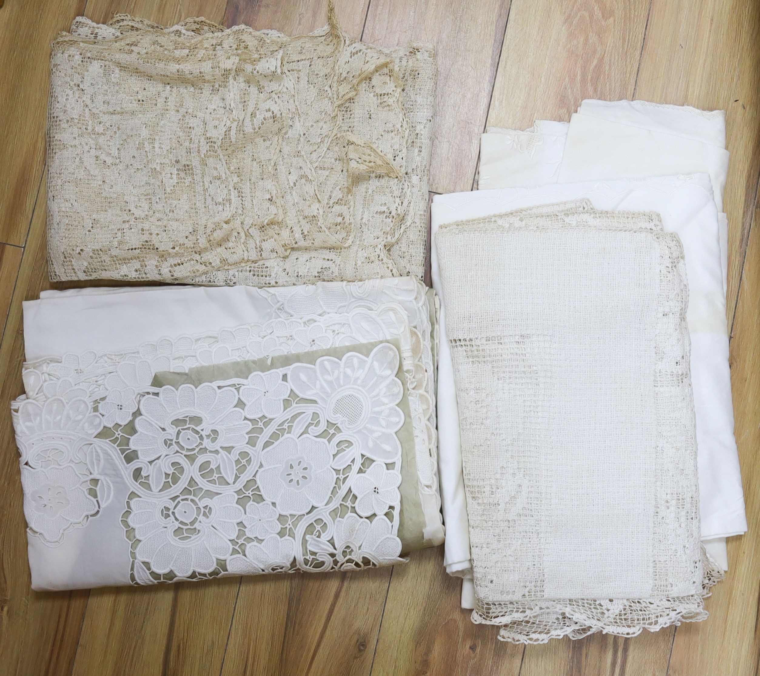 A collection of crochet edged linen tablecloths, a filet cloth and a 225cm long ornately cutworked cloth.                                                                                                                   