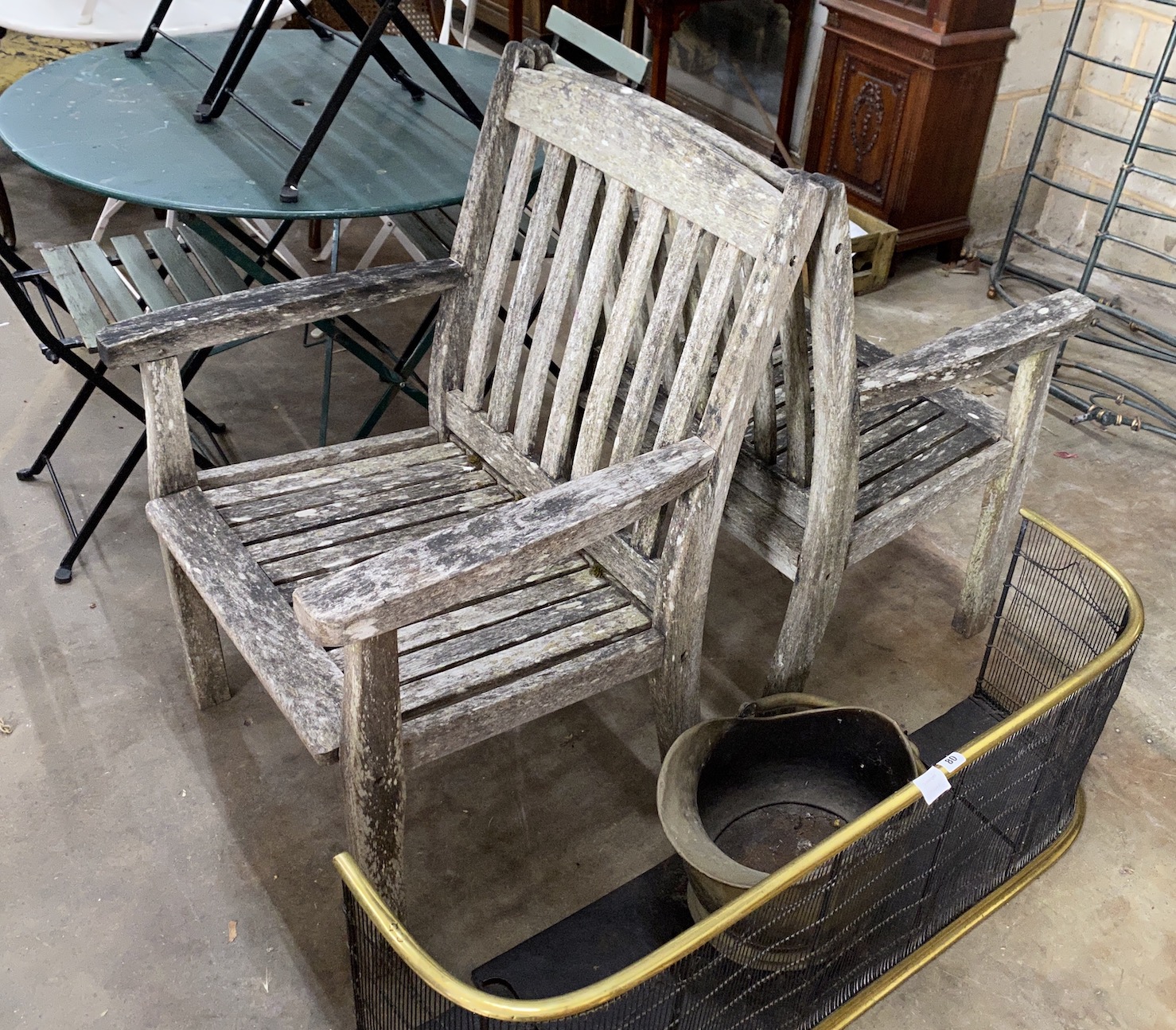 A pair of weathered teak garden elbow chairs, width 68cm, depth 52cm, height 95cm                                                                                                                                           