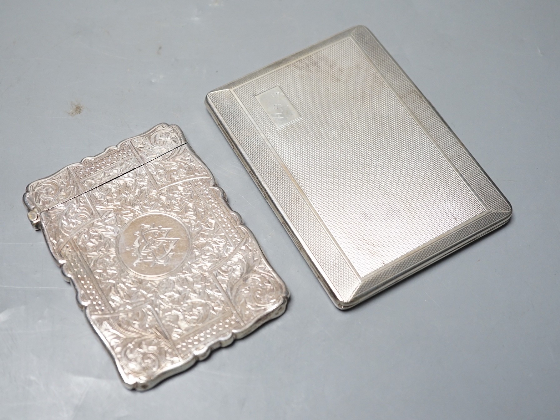 A late Victorian engraved silver calling card case, Birmingham, 1892, 98mm, and a George V engine turned cigarette case.                                                                                                    