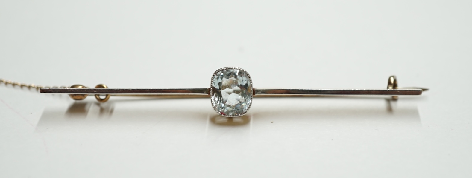 An Edwardian yellow metal and single stone aquamarine set bar brooch, 61mm, gross weight 4.2 grams. Condition - fair                                                                                                        