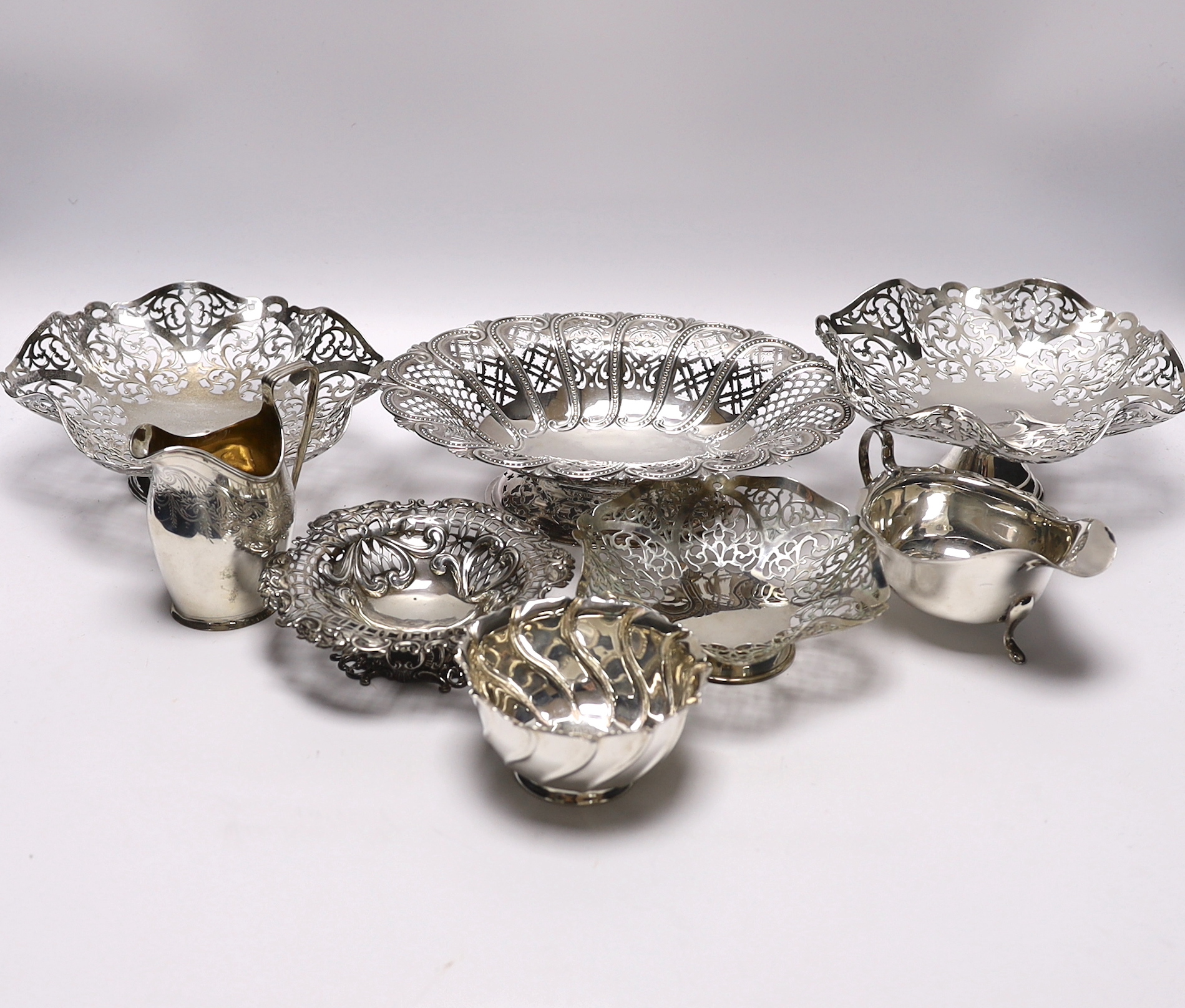 Eight assorted items of Victorian and later silver, including five pierced bowls, largest 22.5cm and a 1960's trio, together with a silver sauceboat, small bowl and cream jug, 35.9oz.                                     