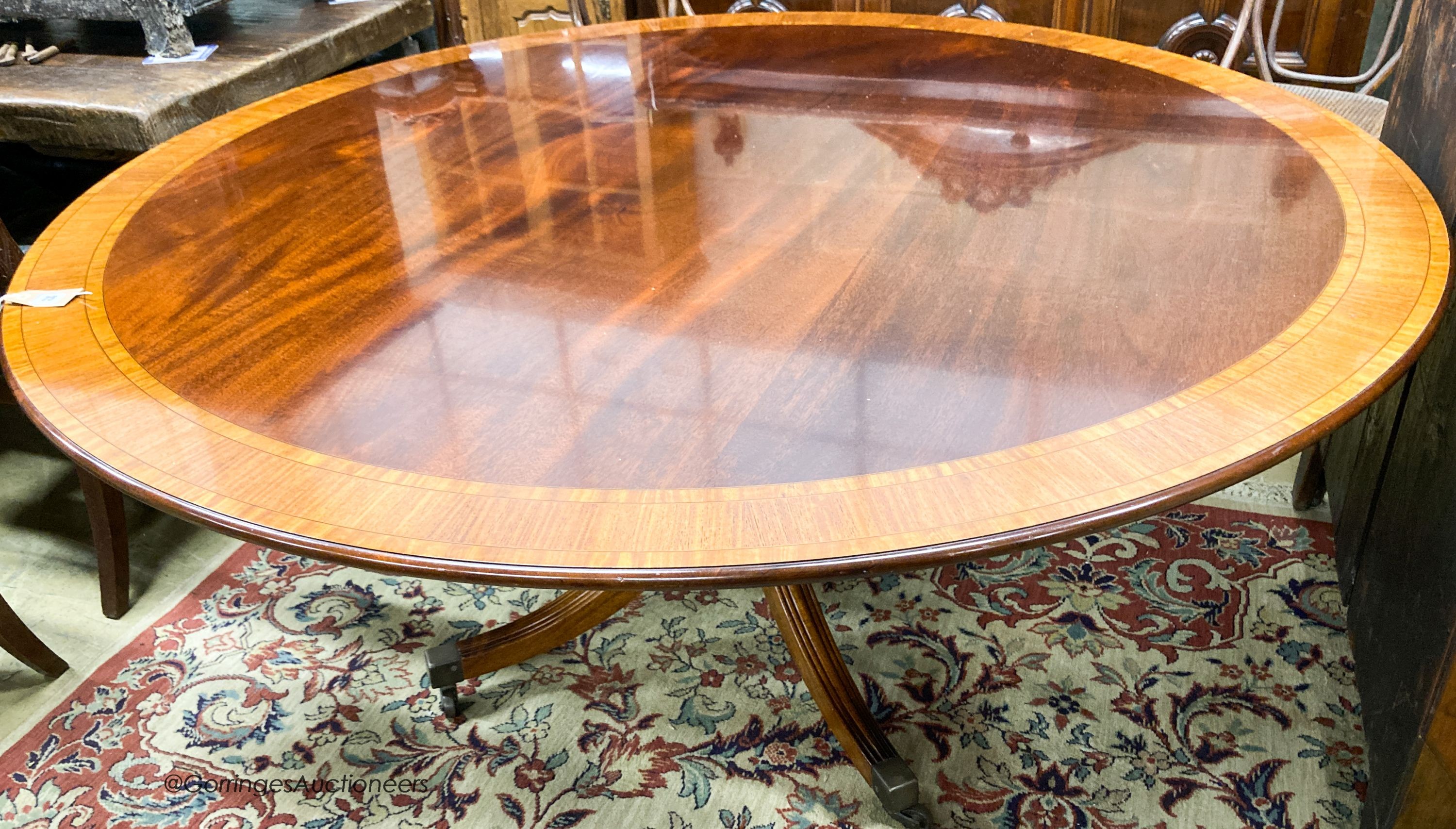A William Tillman Georgian style mahogany and satinwood circular pedestal dining table                                                                                                                                      
