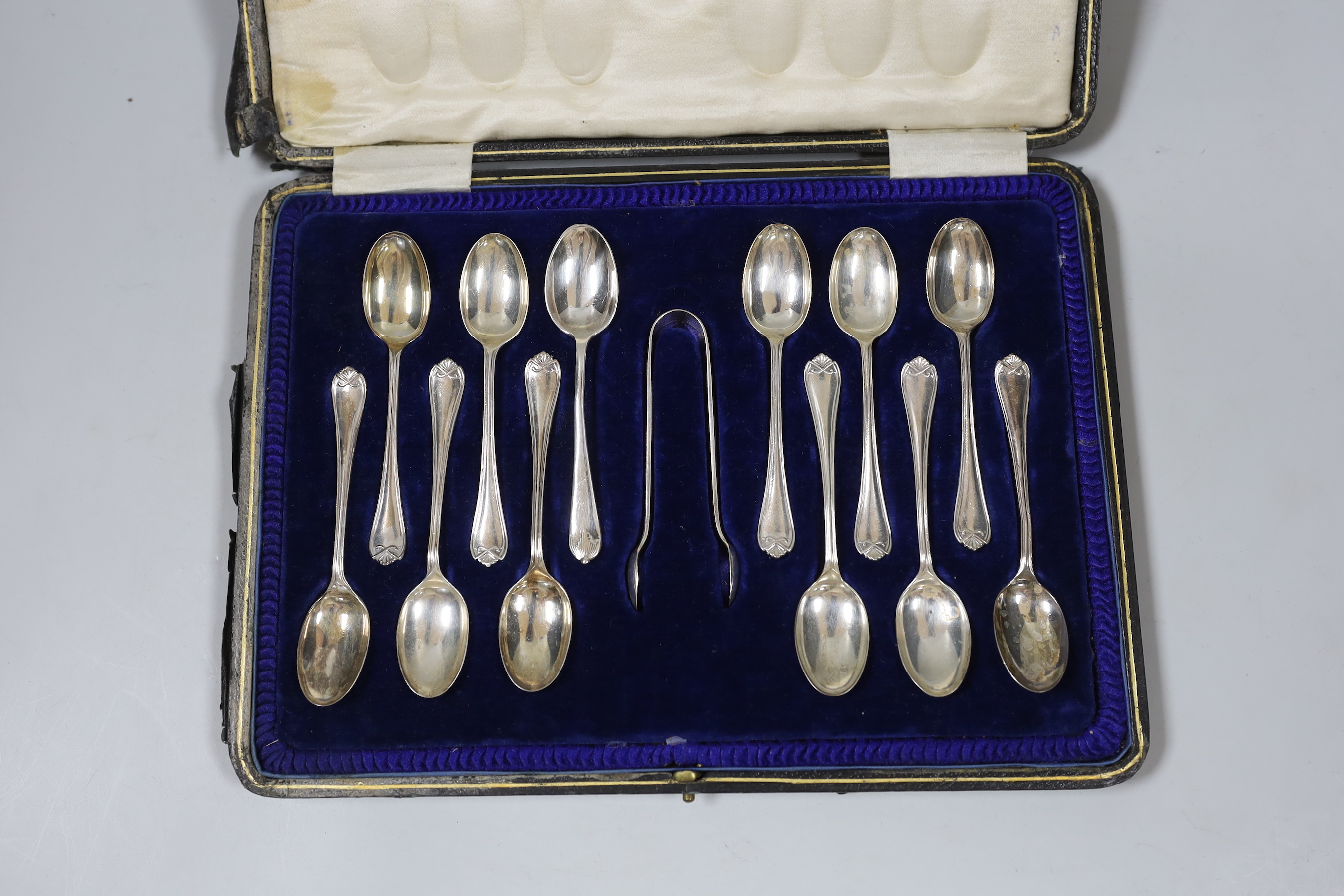 A cased set of eleven George V teaspoons and tongs by Cooper Brothers & Sons and one plated spoon.                                                                                                                          