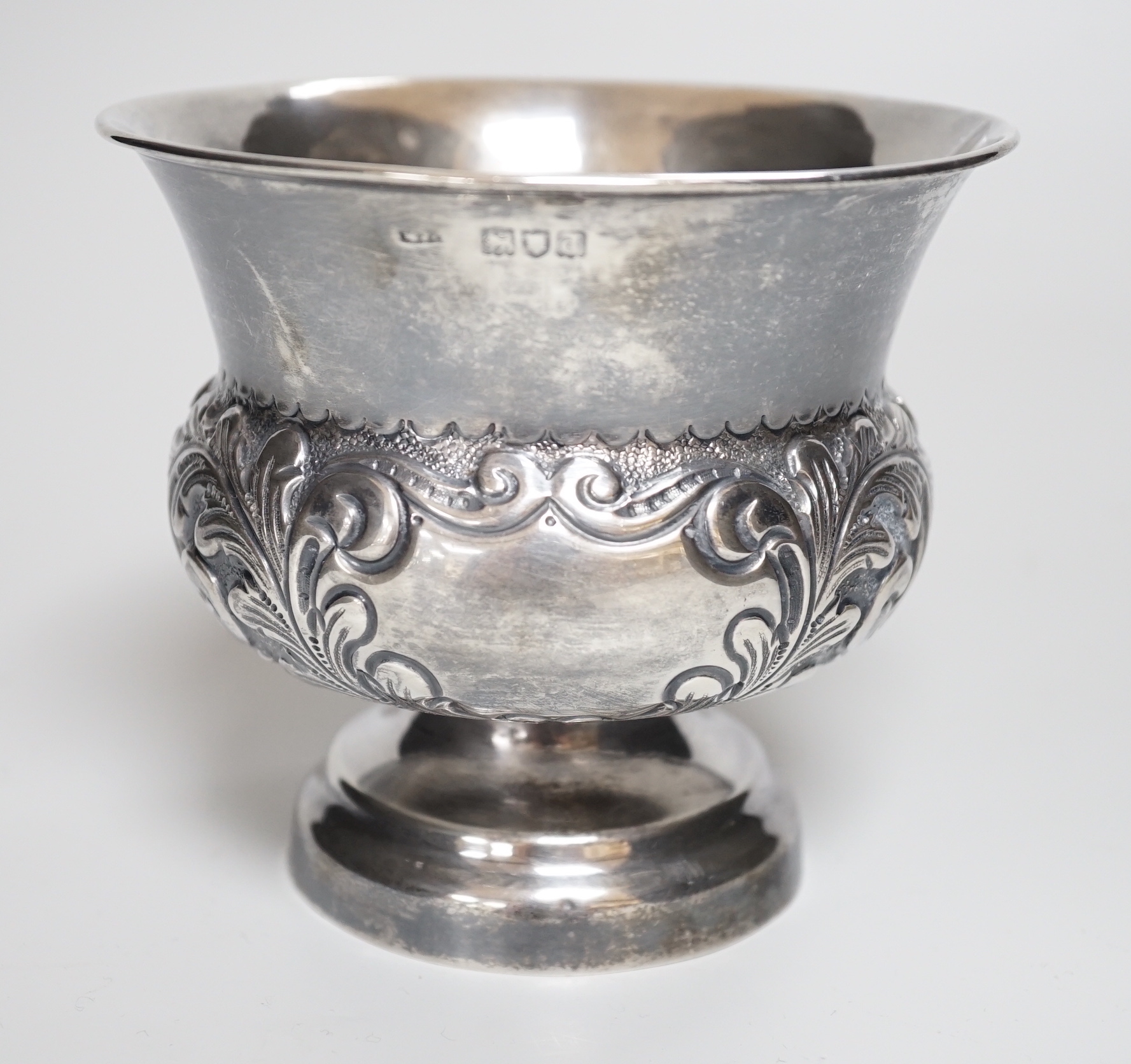 A late Victorian embossed silver bulbous pedestal vase, Matthew John Jessop, London, 1899, height 10.7cm, 6.7oz.                                                                                                            