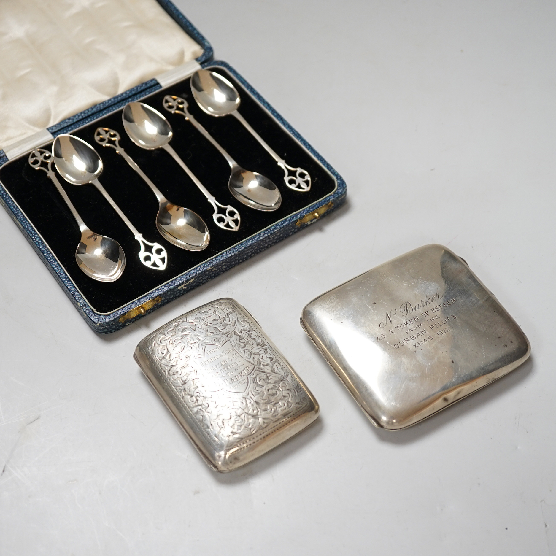 An Edwardian engraved silver cigarette case, 1901, 76 grams, a George V cigarette case with inscription from the Durban Pilots 1922, 102 grams and a cased set of six George V teaspoons, 58 grams                          