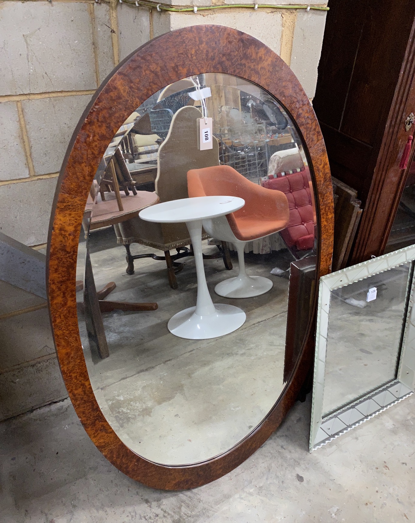 An early 20th century French oval amboyna wall mirror, width 138cm, height 88cm                                                                                                                                             