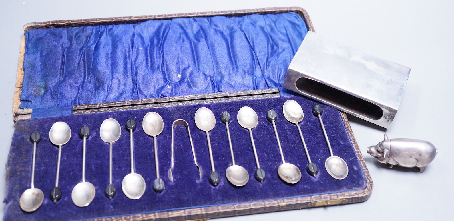 A cased set of twelve George V silver bean end coffee spoons and pair of sugar tongs, William Suckling Ltd, Birmingham, 1925/6, a modern 925 pig vesta case and a large silver matchbox sleeve.                             