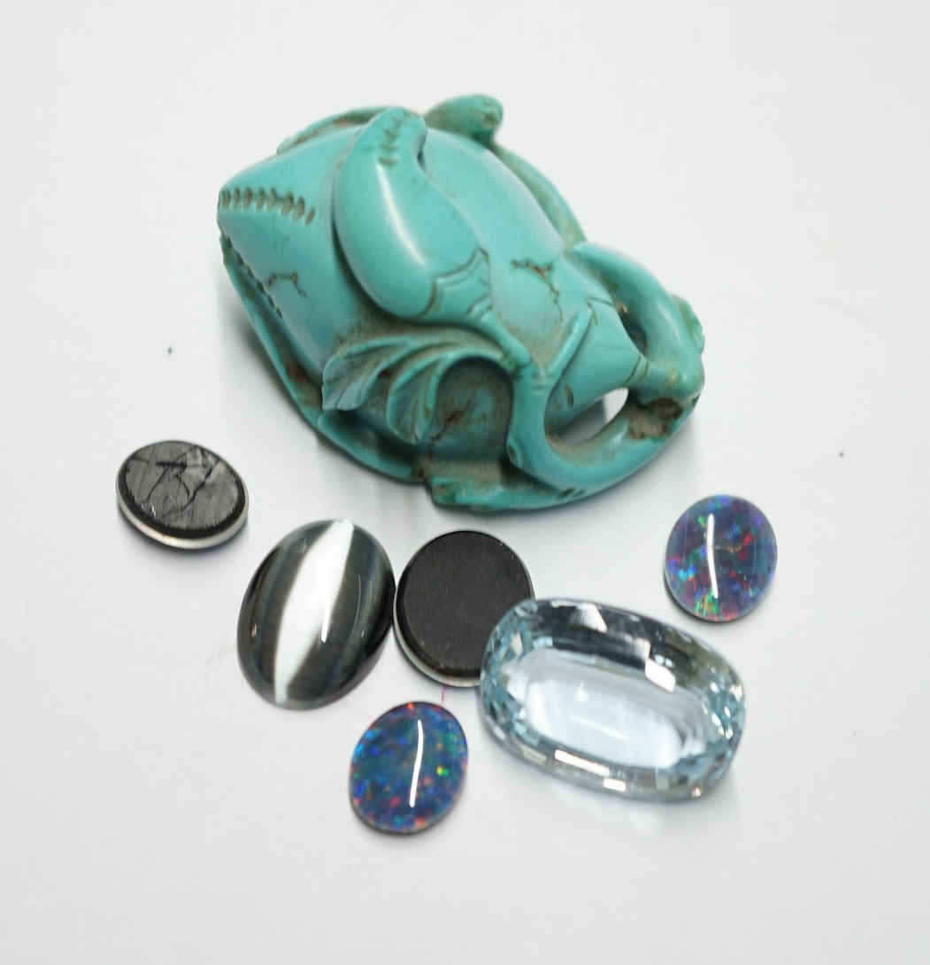 A turquoise carving and a small group of unmounted stones including opal doublets and chatoyant and a blue topaz. Condition - fair                                                                                          