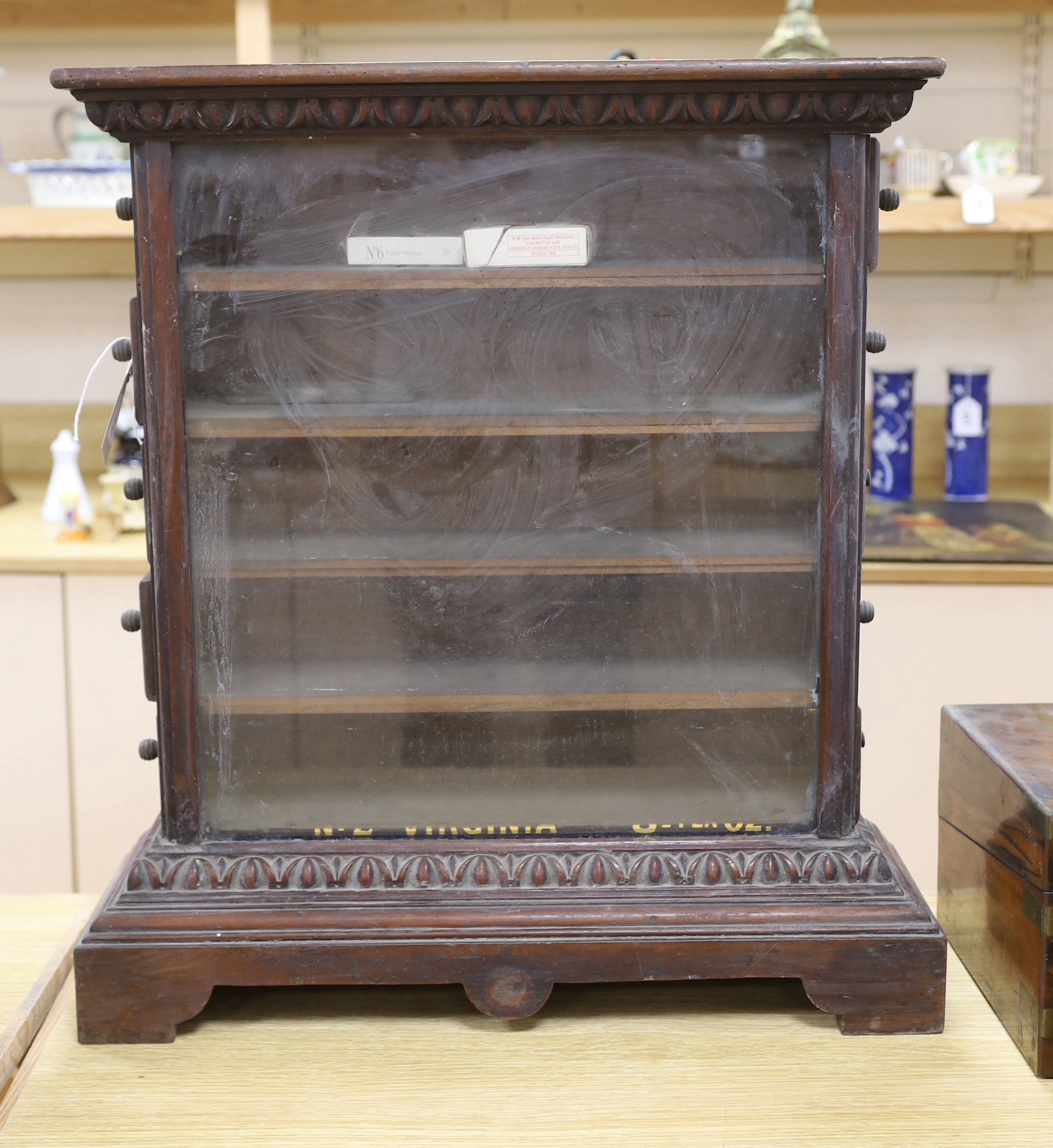 A glazed and carved mahogany cigarette shop display cabinet with remnants of gold lettering to the front, GA Mossman, Hastings stamp to the reverse, 61cm high                                                              